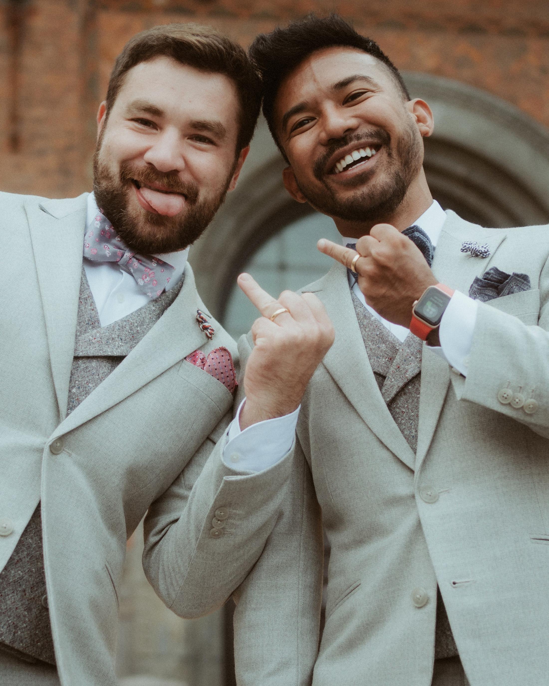Kris and Ilya smile toward the camera and hold up their wedding rings.