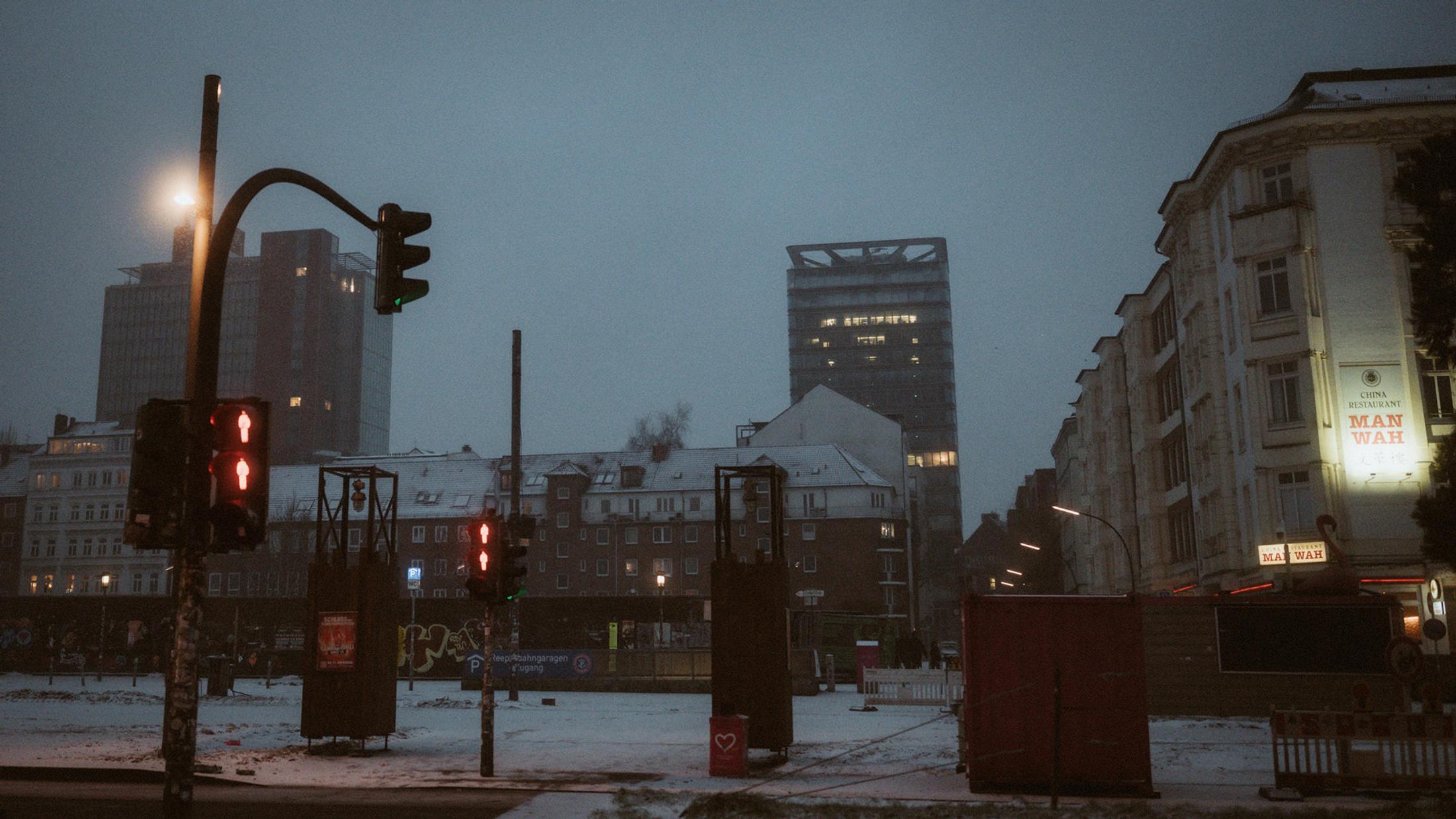 Snowy Hamburg streets and traffic lights at blue hour near St. Pauli.