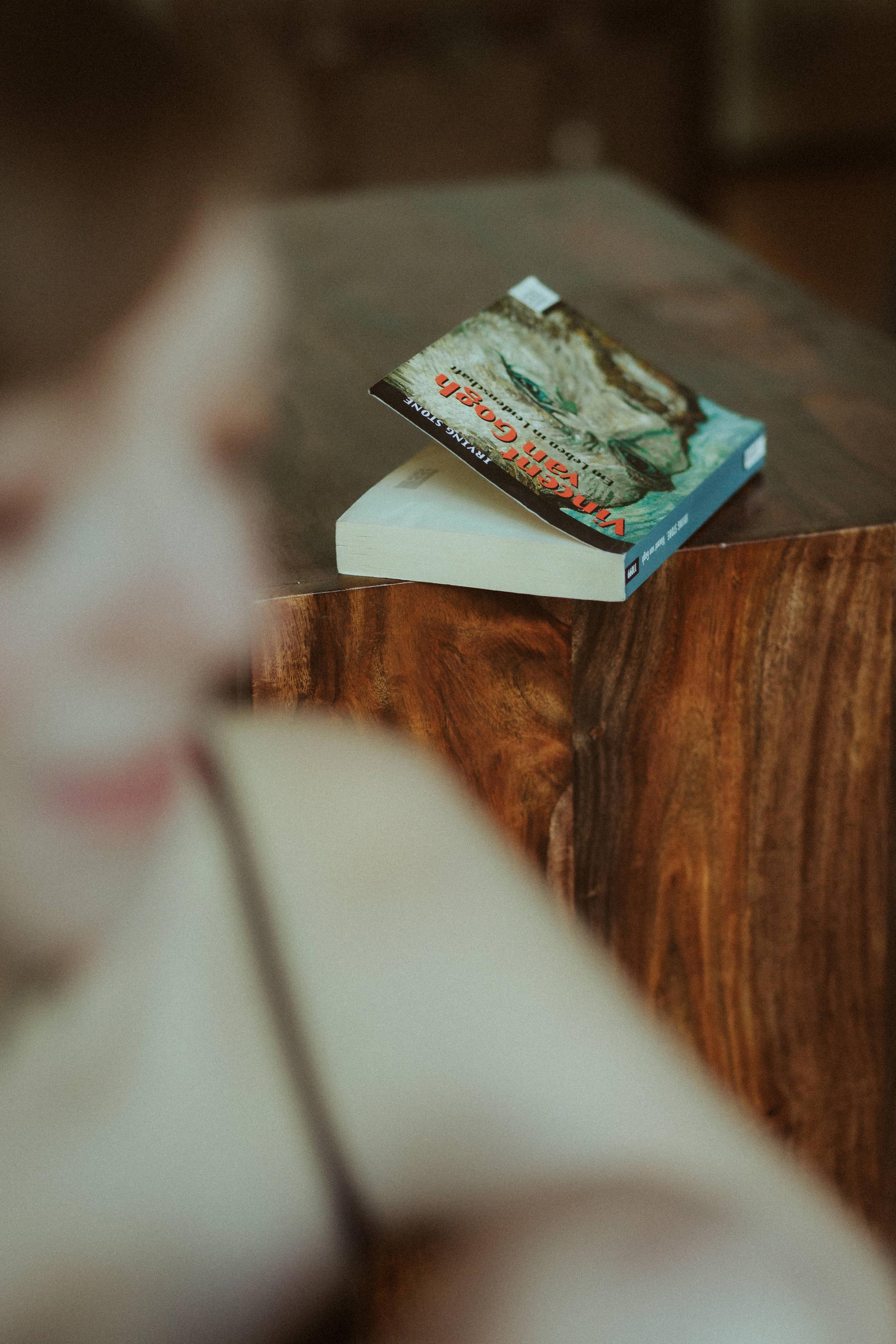 A small book rests on the wooden surface of a chest.