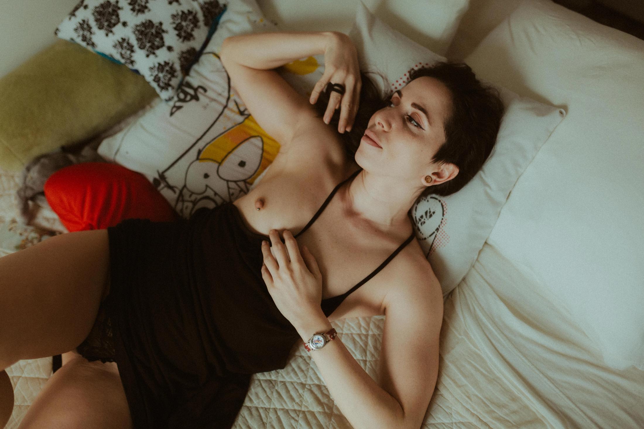 Overhead portrait of Maya in black on a patterned bedspread.