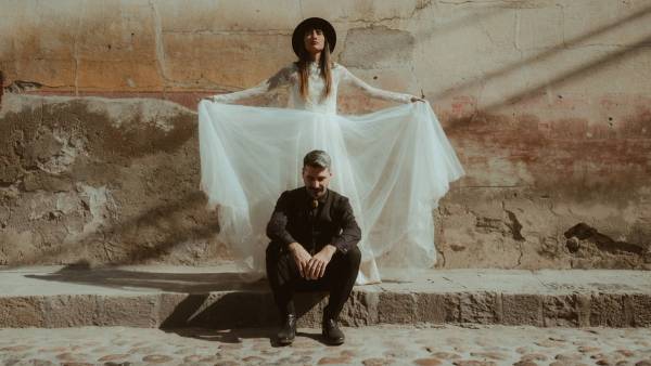 Anna spreading her dress behind Nahuel in a constructed portrait.