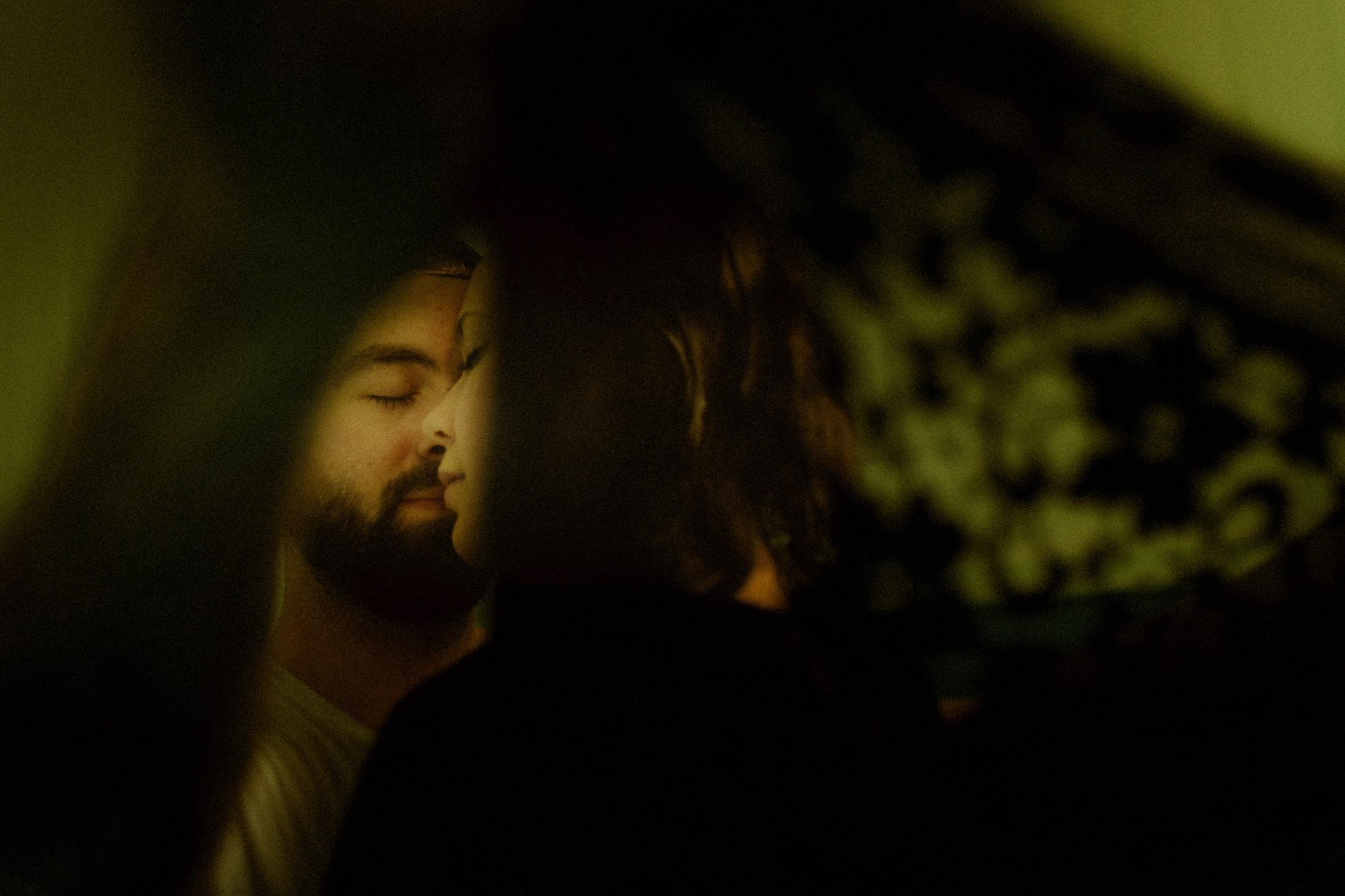 Annie and Daniel are reflected close together in dark green light.