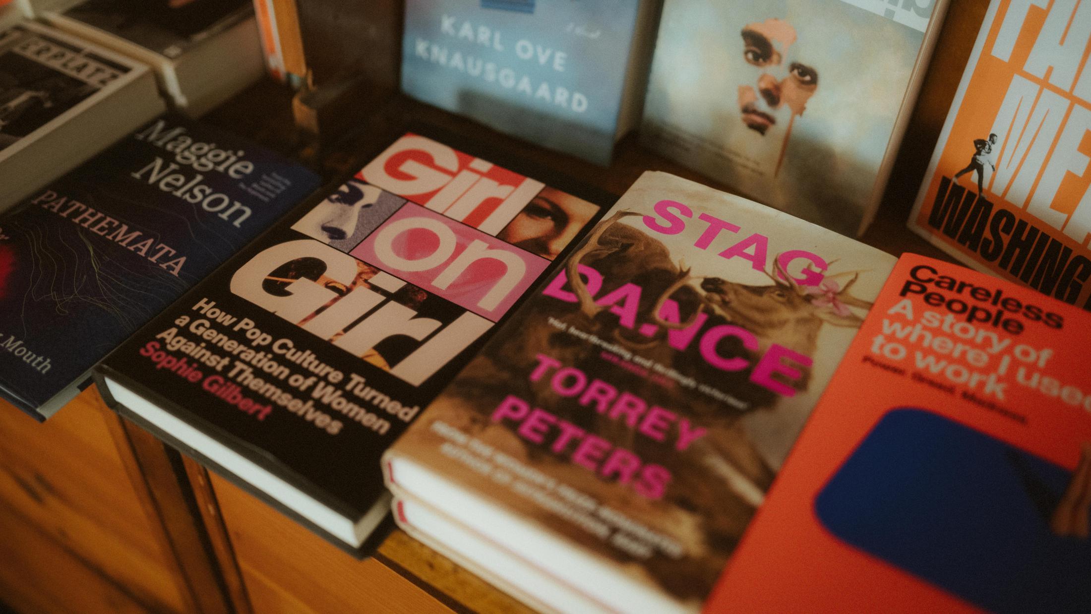 A table covered with books about queer culture, feminism and art.