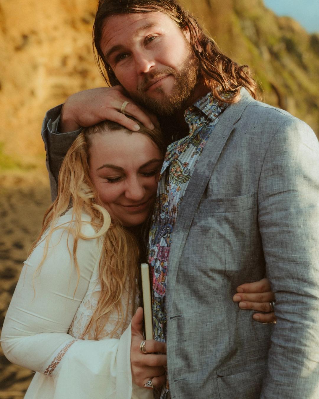 One of the newlyweds rests their head on the other's shoulder.