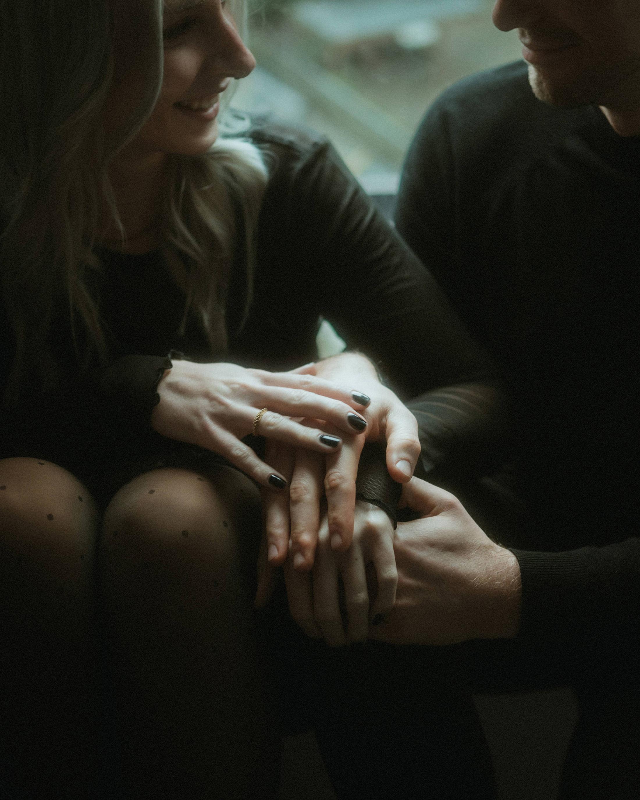 Close view of Lorelai's and Steffen's hands resting together in the hotel room.