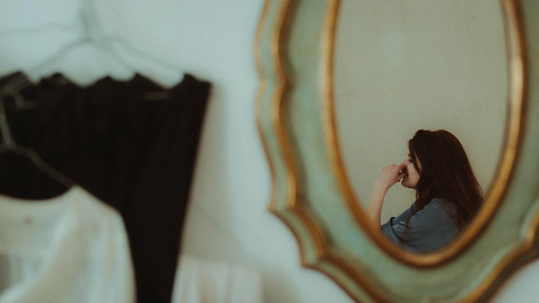 Woman seen at a distance in an old mirror
