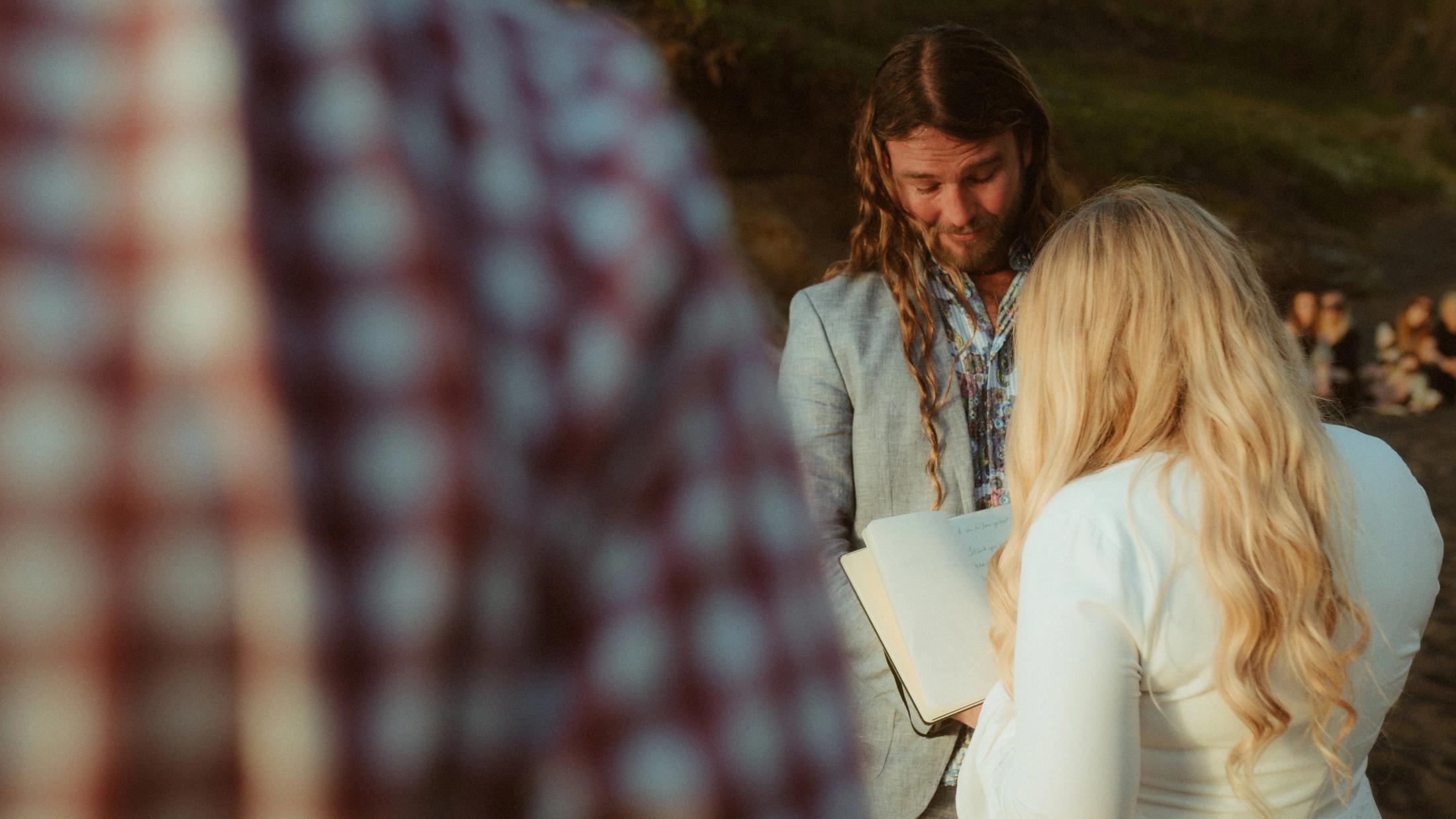 Twyla and Gary face the officiant during their intimate beach ceremony.