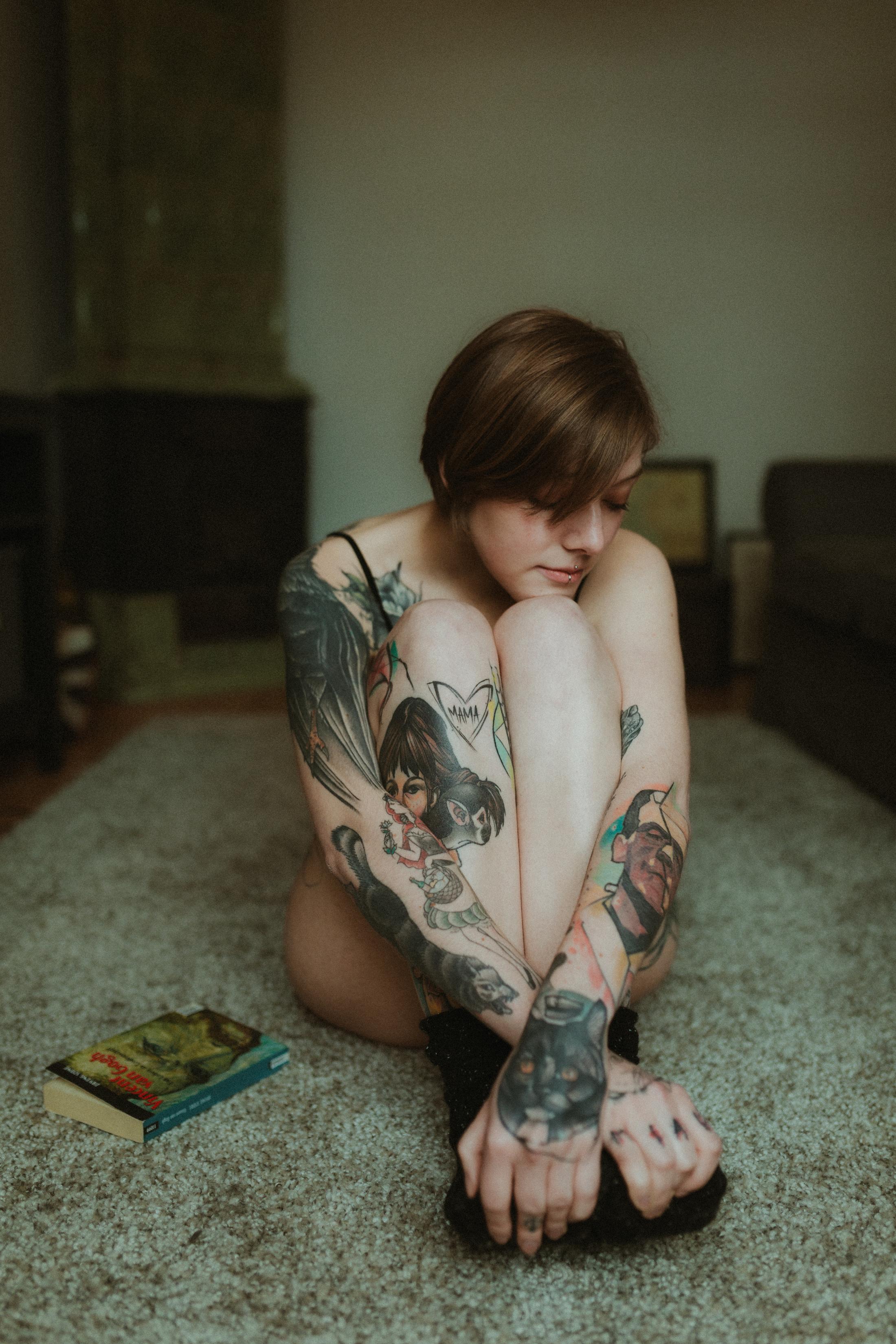 Anki sits on the floor with her arms resting around her knees.