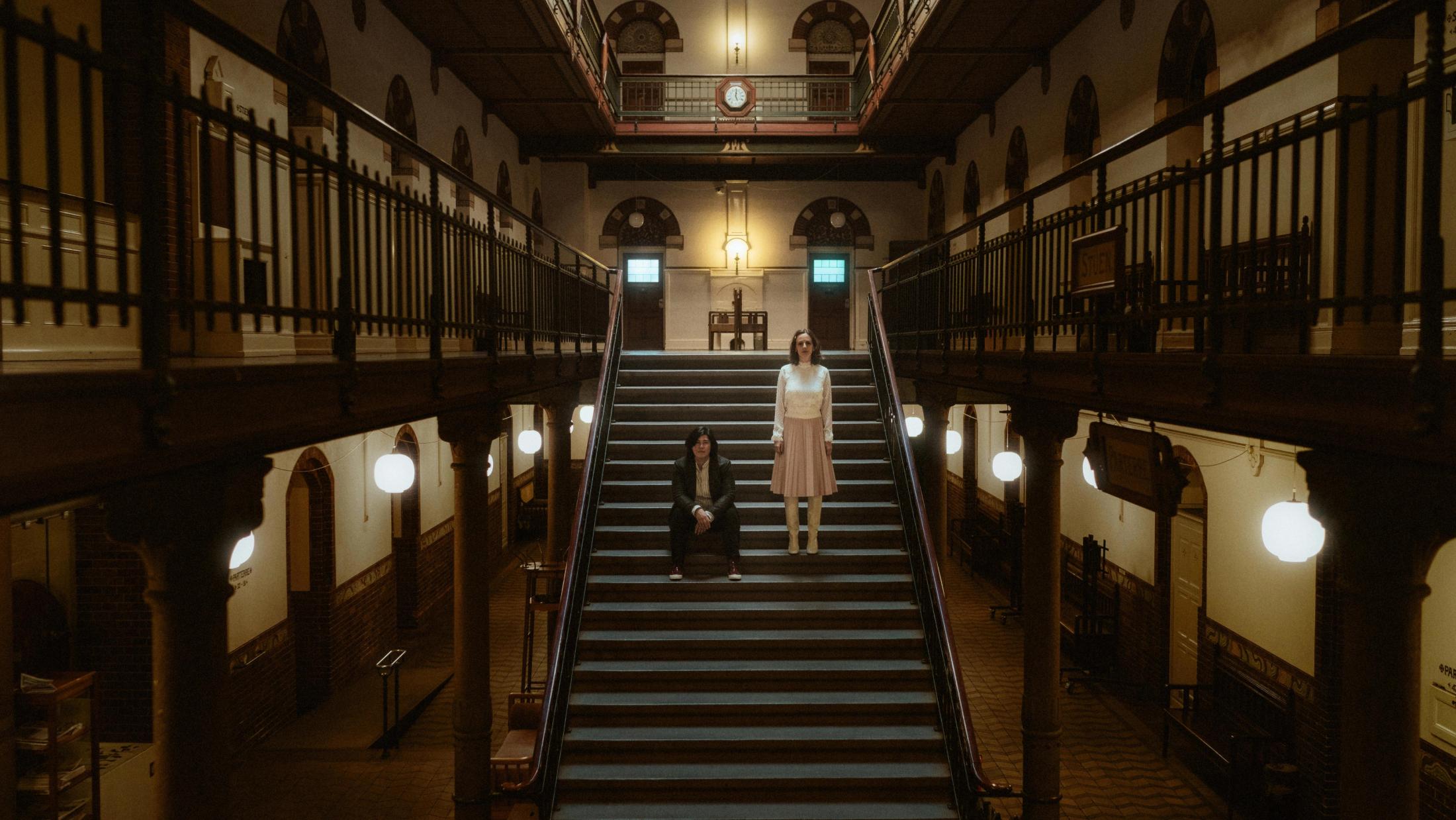 Ari and Pia separated by the geometric lines of a City Hall staircase