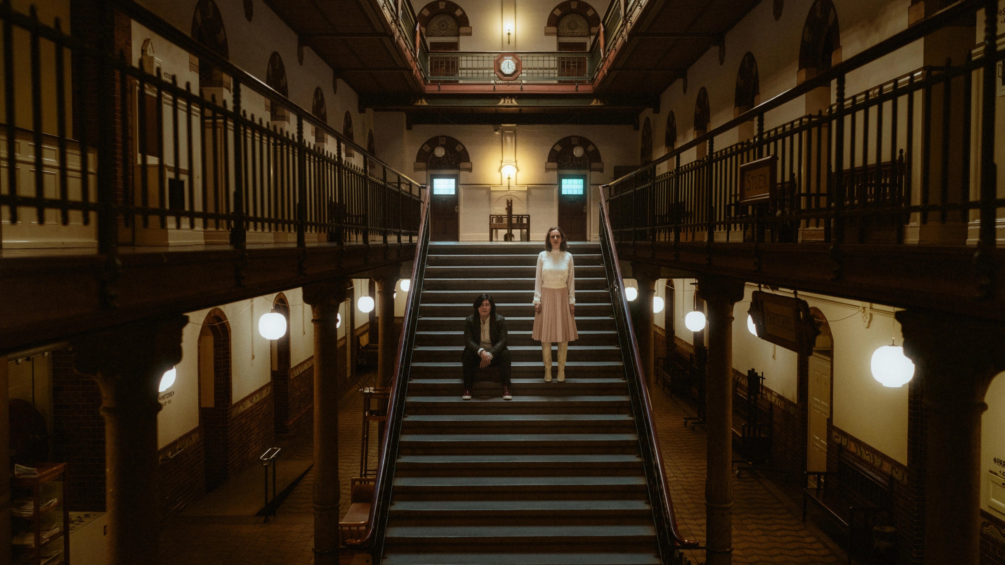 Ari und Pia stehen getrennt voneinander in der symmetrischen Treppe des Kopenhagener Rathauses