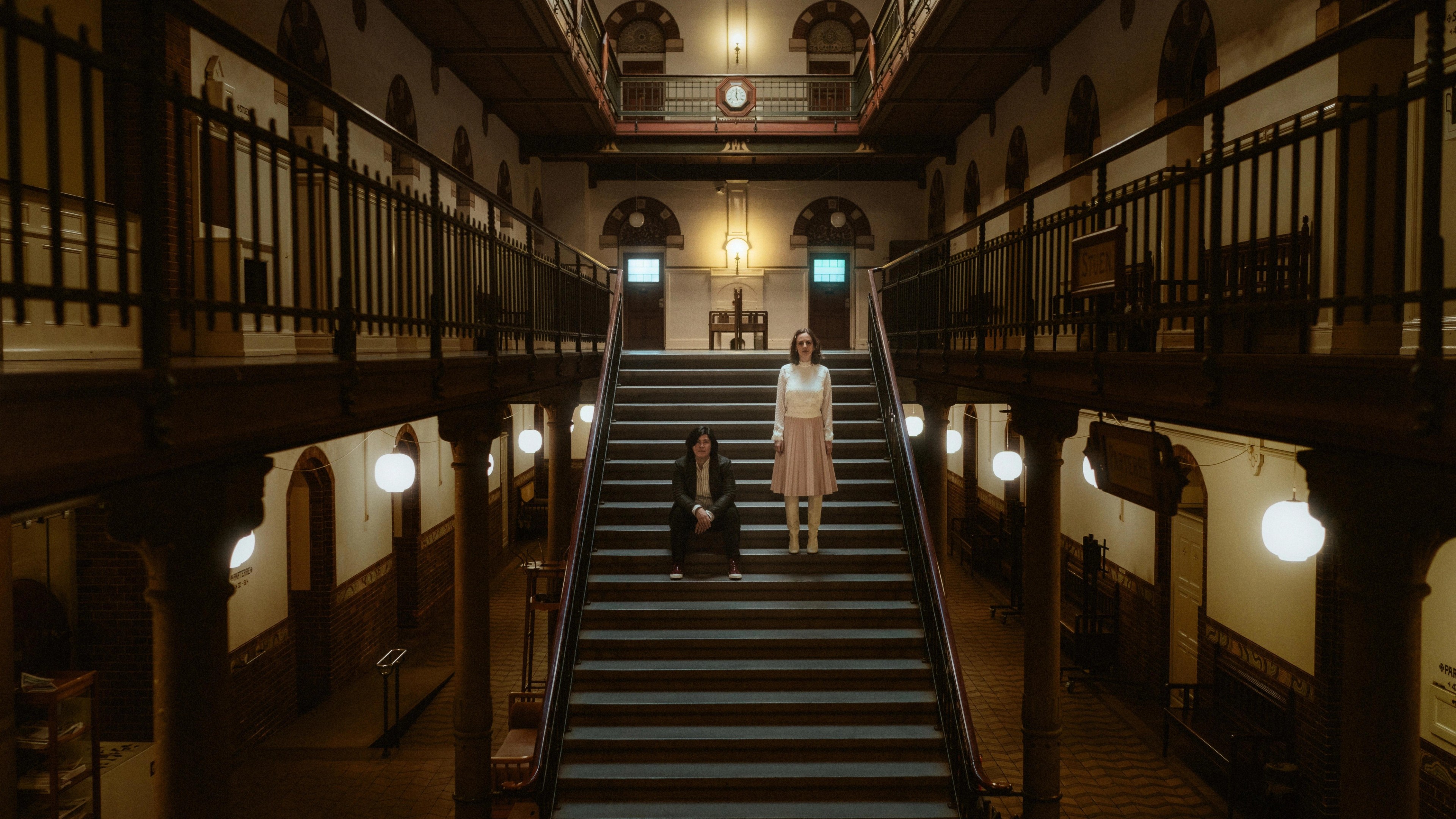 Ari and Pia separated by the geometric lines of a City Hall staircase