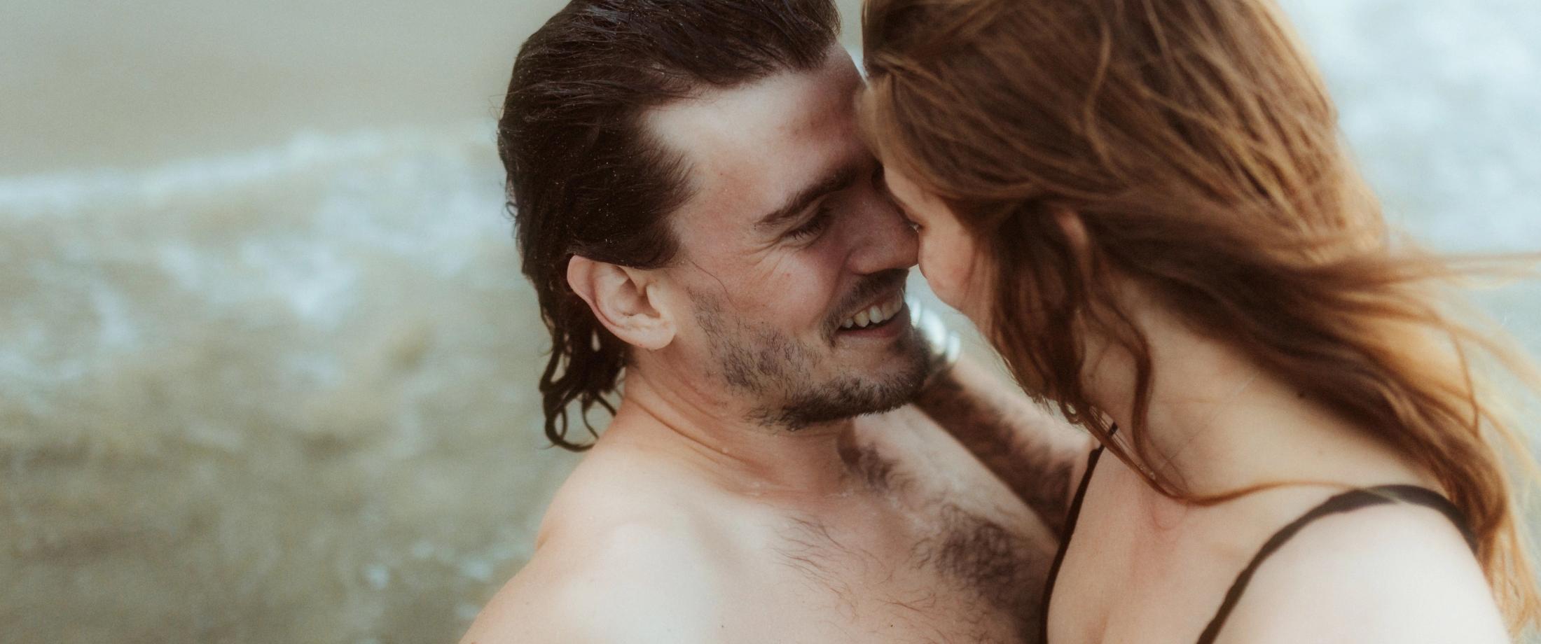 Paar küsst sich am Wasser, Wasser läuft der Frau über den Rücken, Hafenliebe