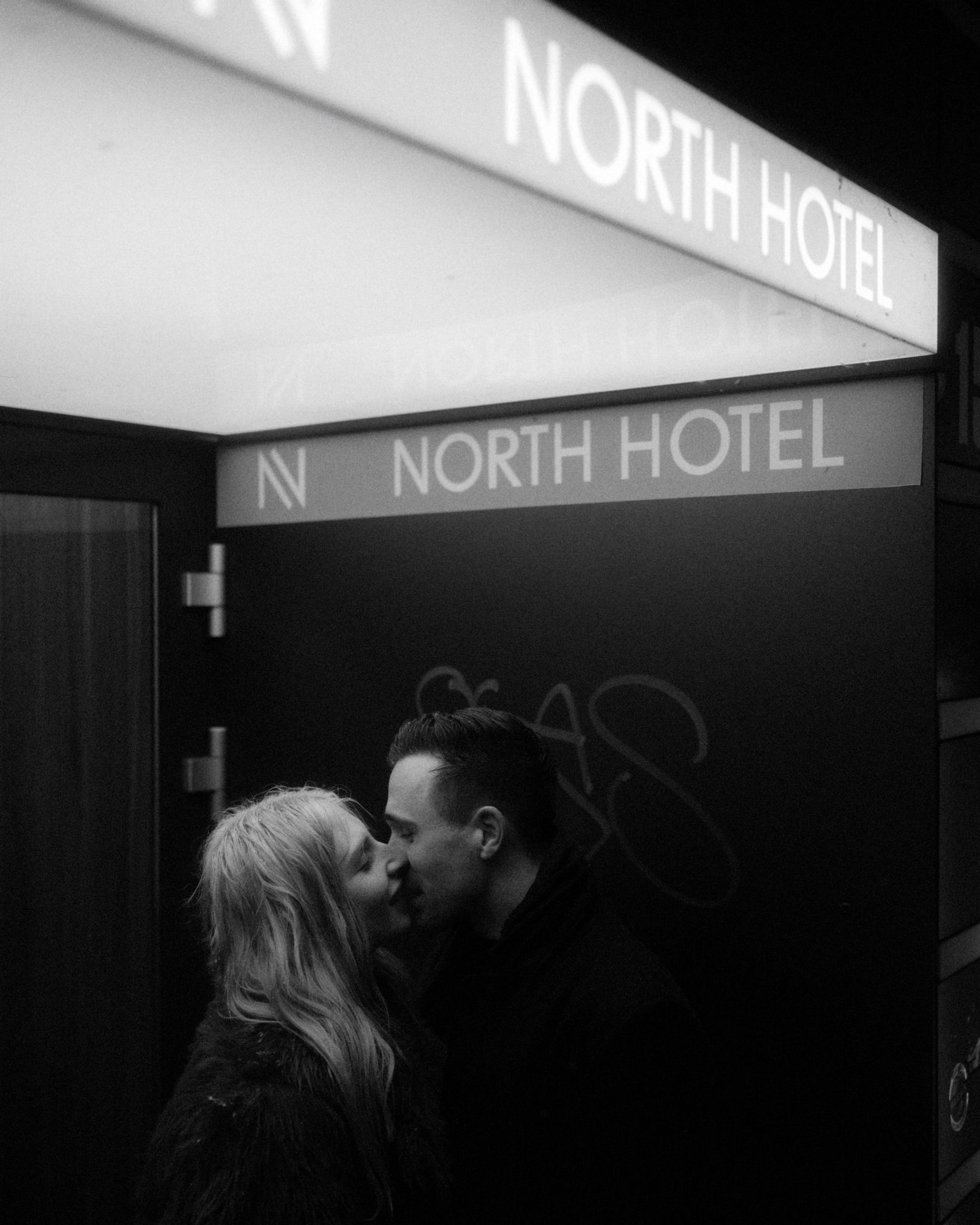 Lorelai and Steffen kiss beneath the illuminated North Hotel sign.