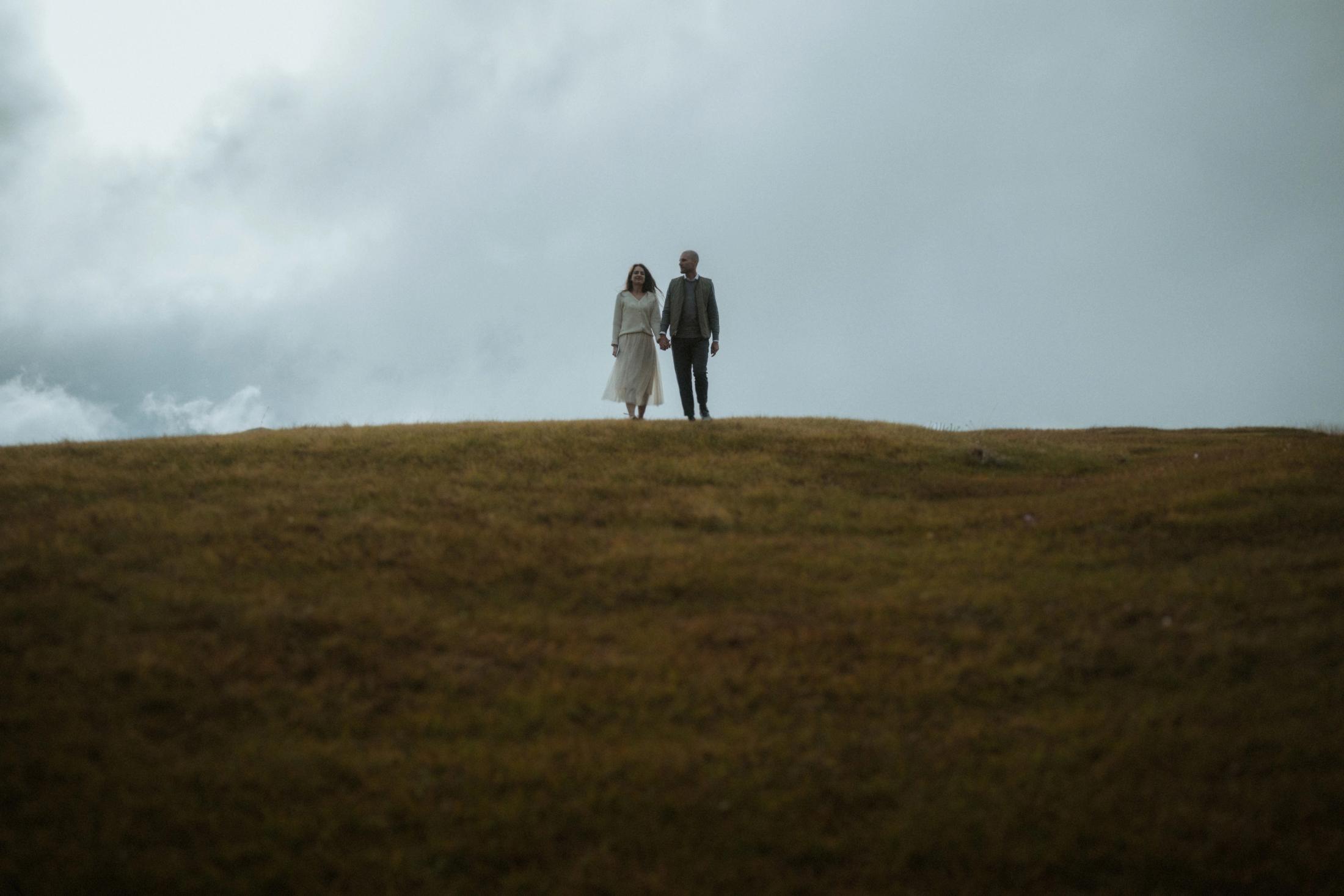 Jana and Steffen standing together on a distant mountain ridge.