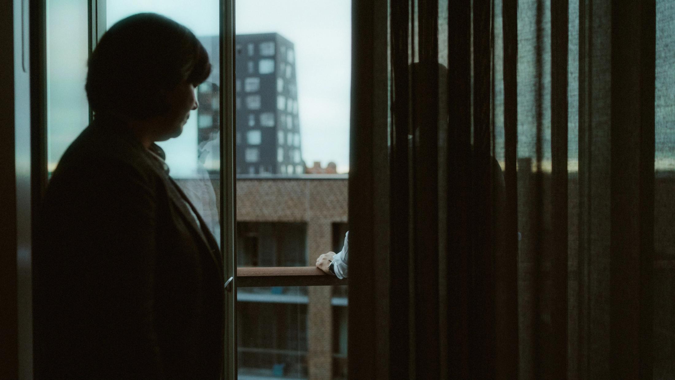Pia silhouetted beside an apartment window
