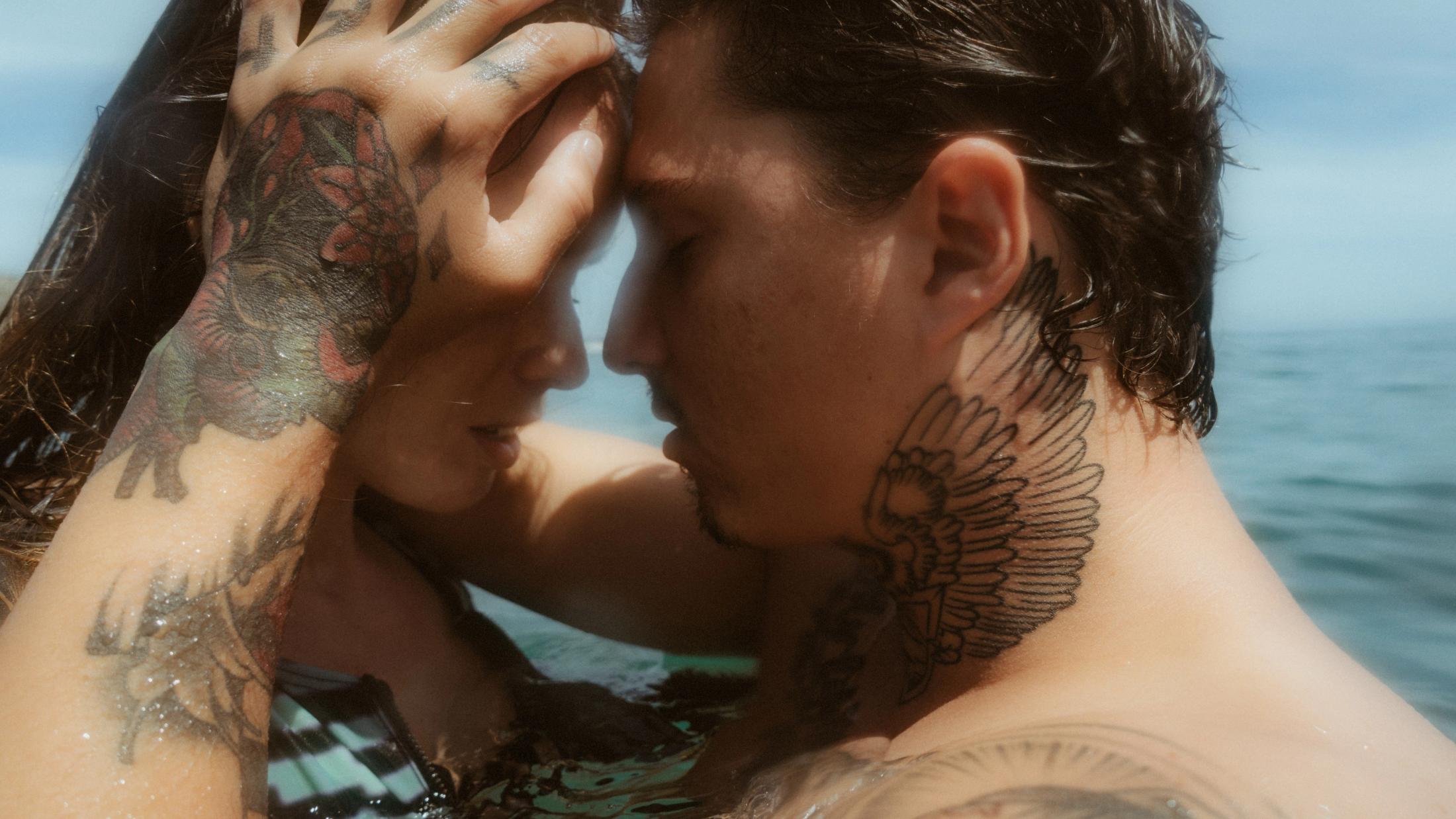 Enge Umarmung, dazwischen ein Handtattoo sichtbar.