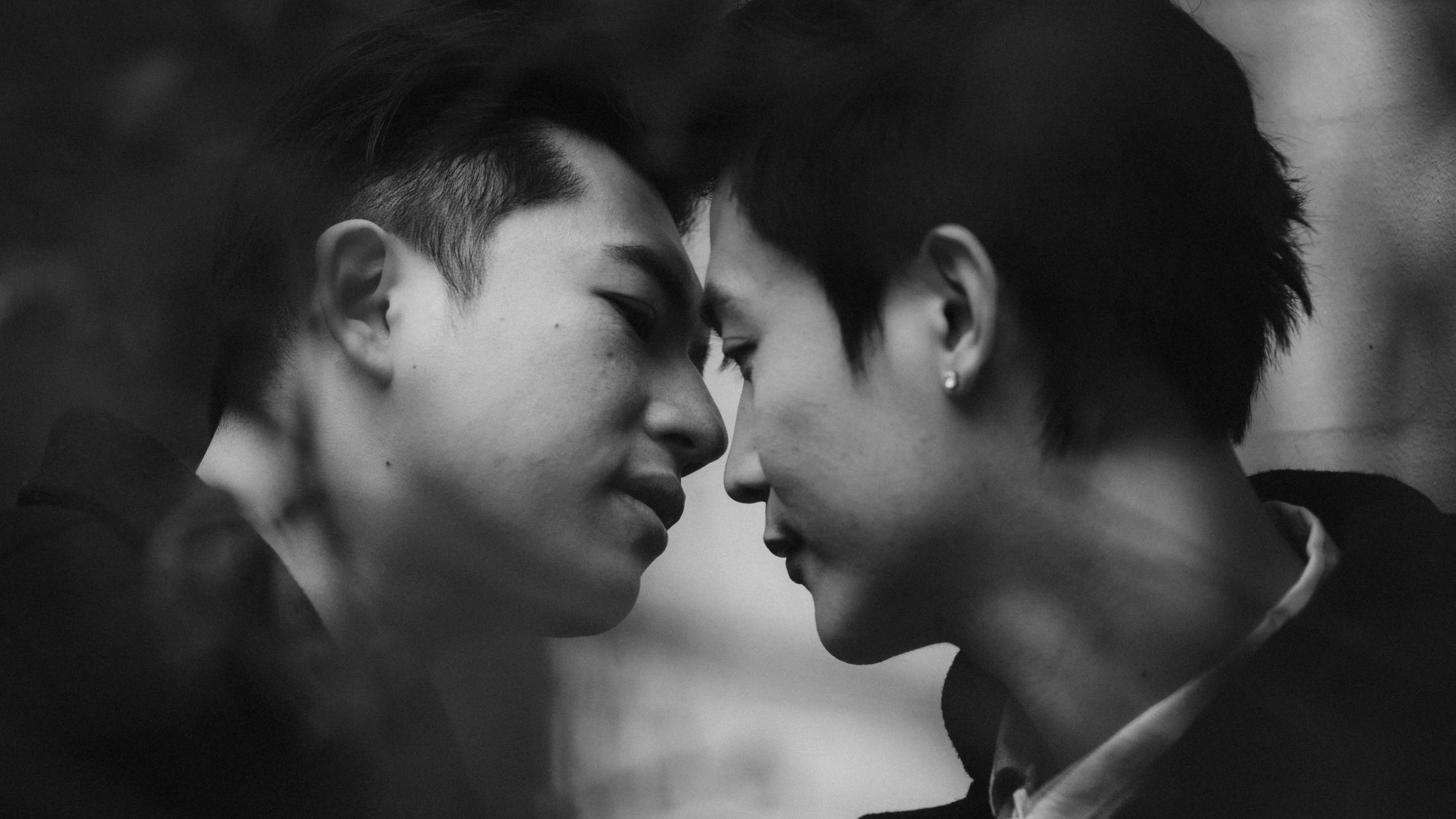 Kevin and Terence lean their foreheads together in a close black-and-white portrait.