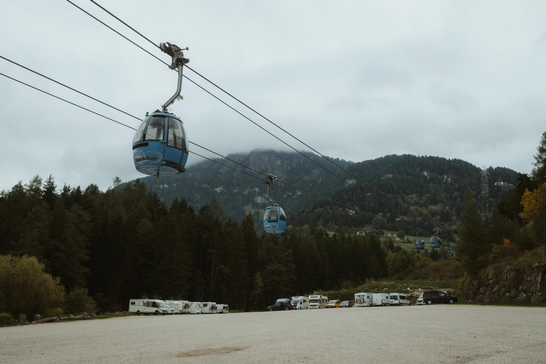 A cable car travelling into low cloud above the valley.