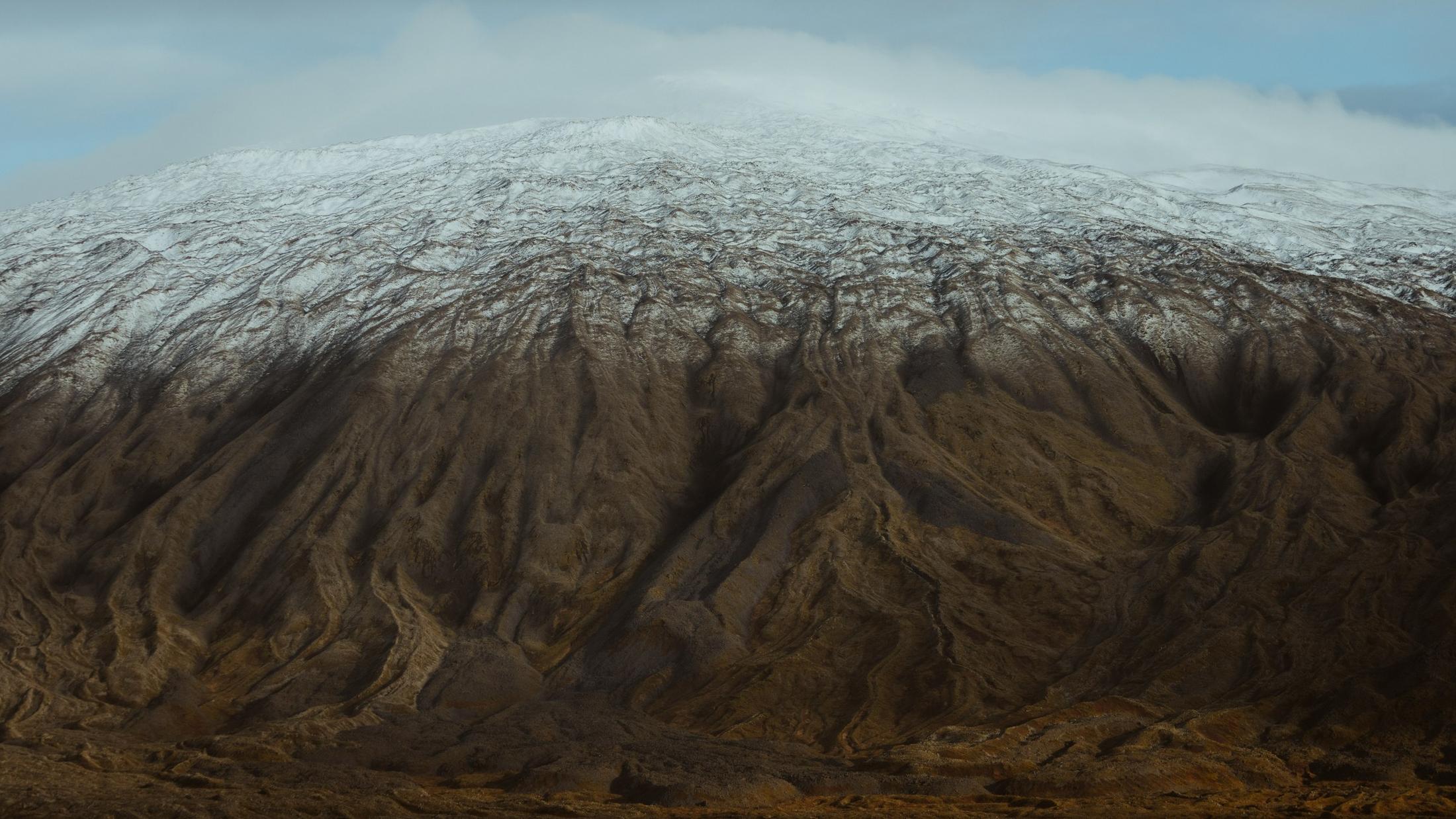 Snow tracing the ridges of an Icelandic mountain.