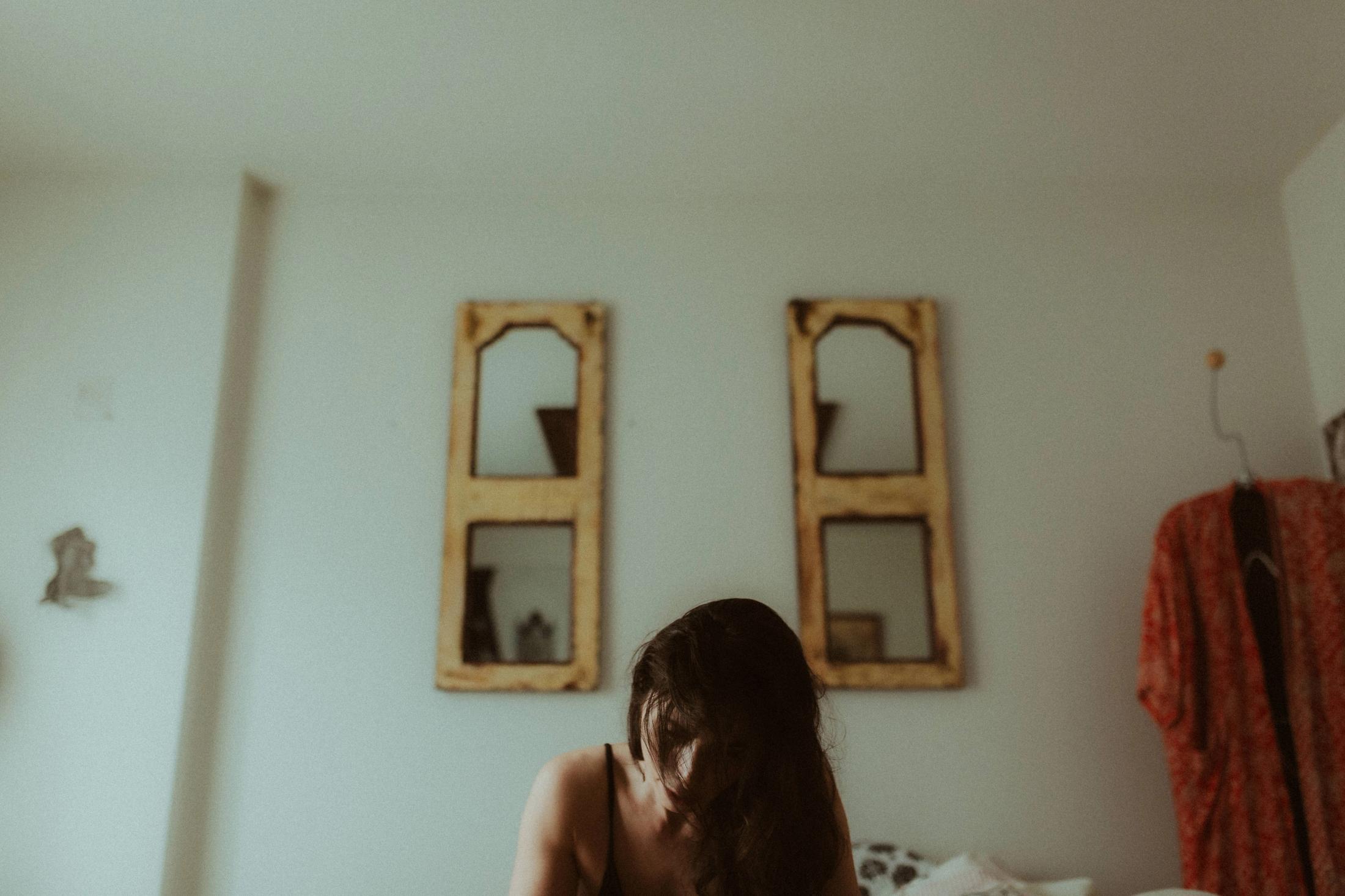 Maya low in the frame beneath two weathered mirrors.