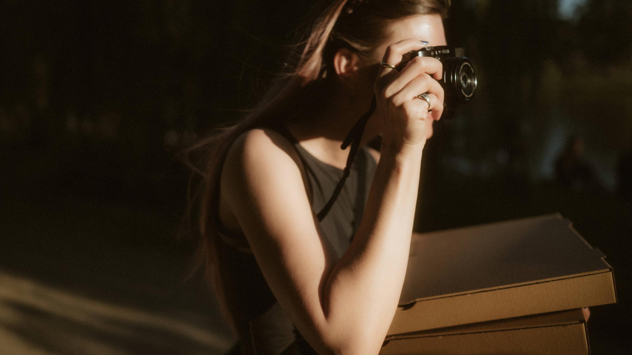 Michèle photographing in a hard strip of low evening sunlight.