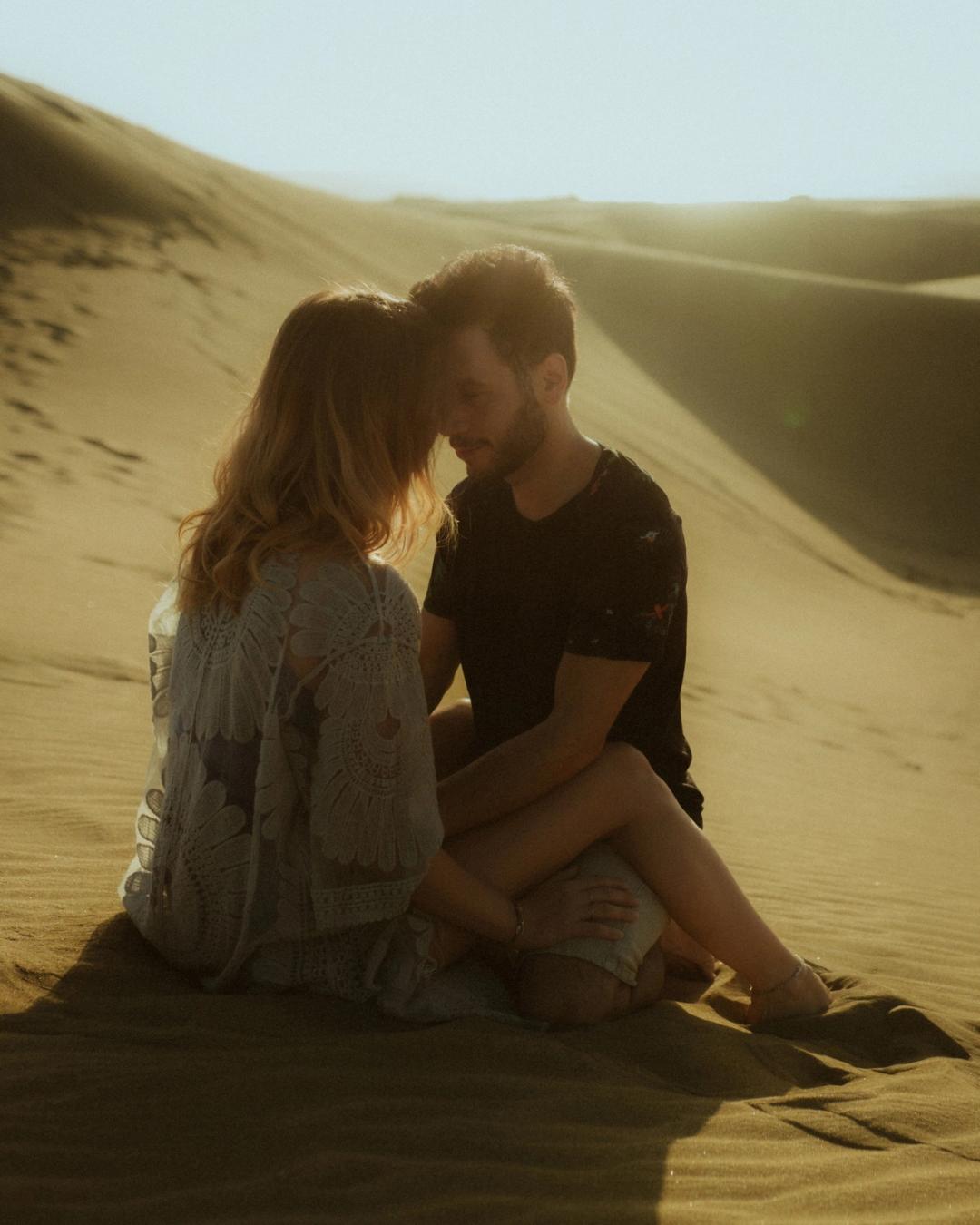 Katja and David sitting quietly together on the sand.