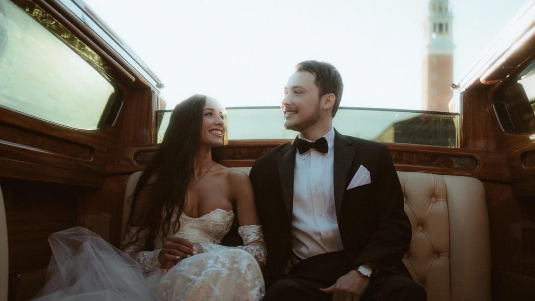 Ein Paar lacht gemeinsam während einer Bootsfahrt durch Venedig an seinem Elopement-Tag
