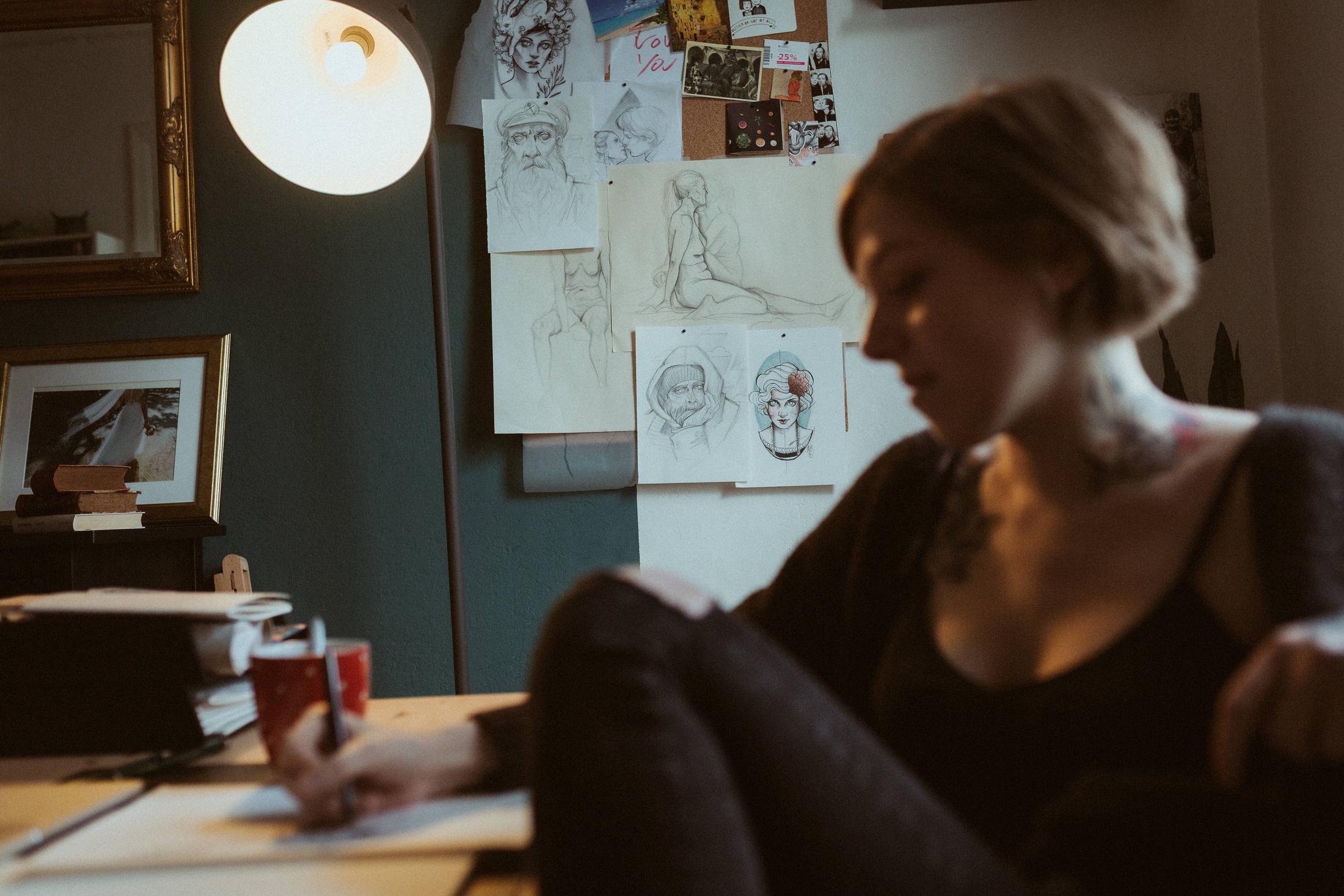 Anki draws at her desk in her Sternschanze apartment.