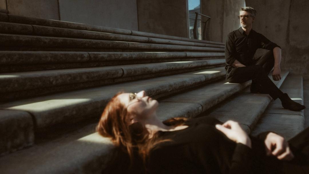 Nicole and Fritjof lying together across concrete steps