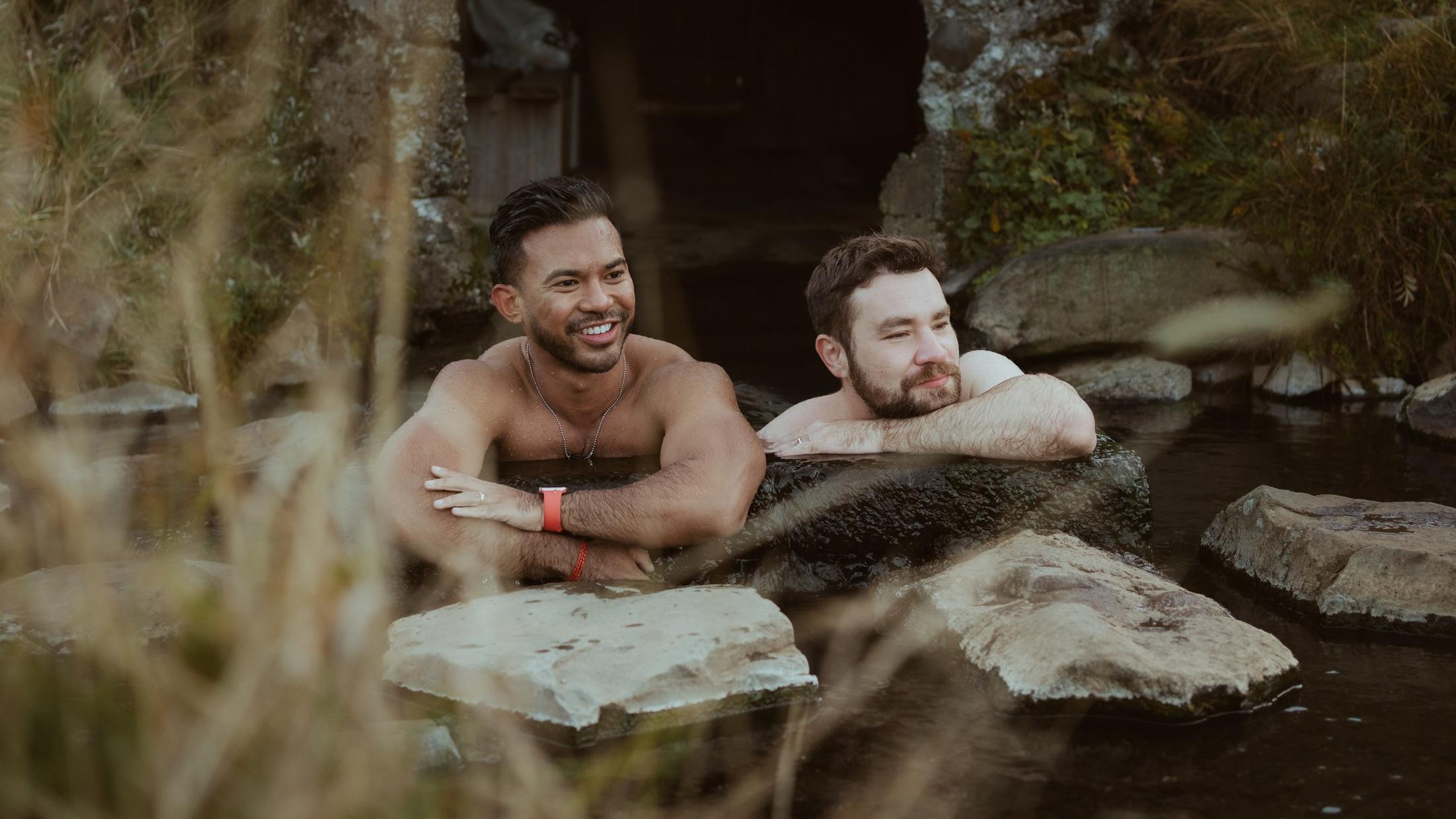 Two people smiling together at the edge of a pool.