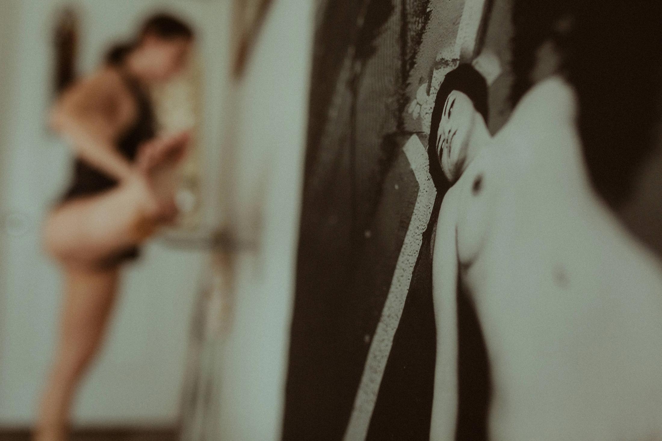 A softly blurred view of Maya facing the artwork in her room.
