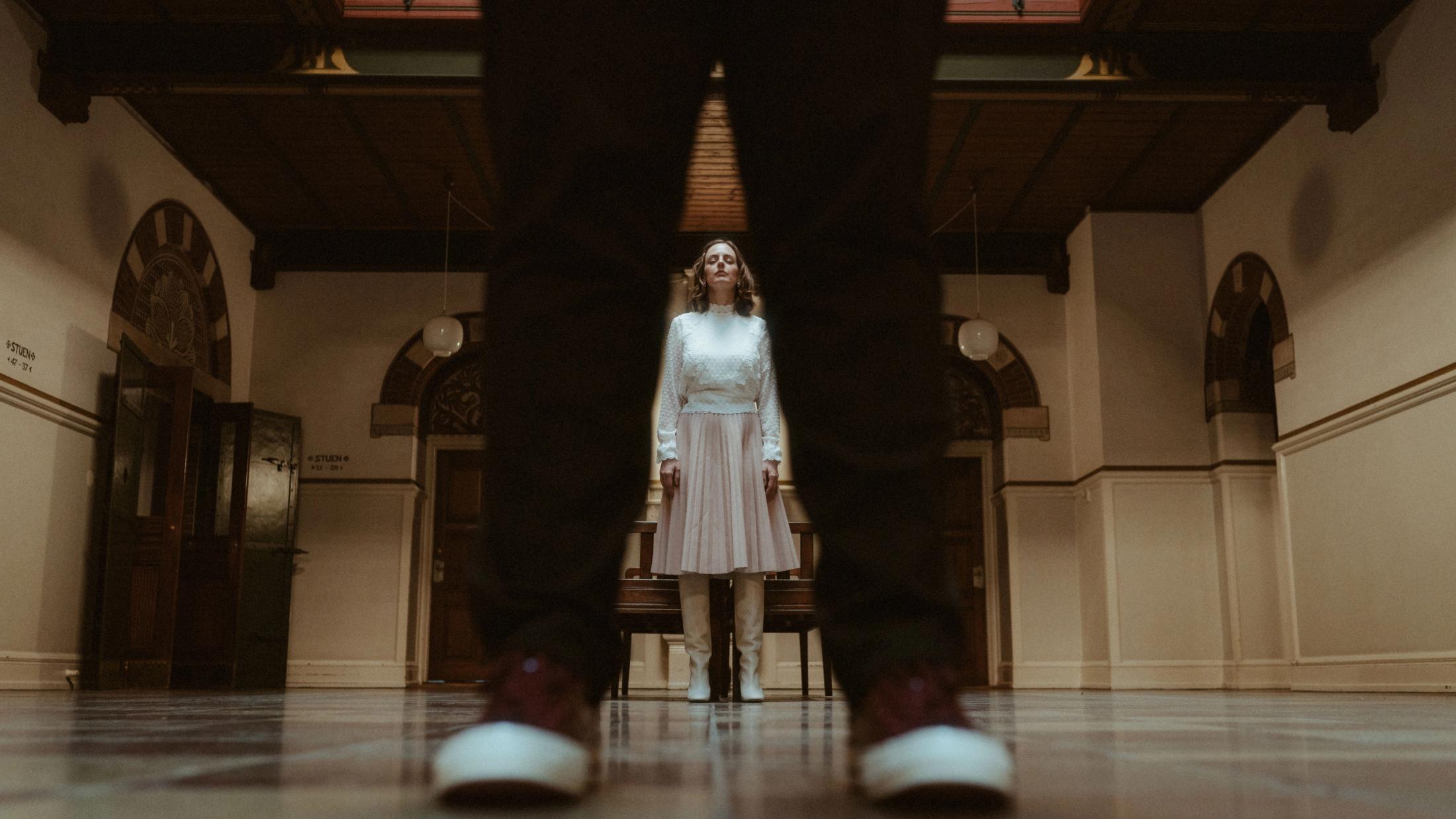 Ari framed between Pia's shoes in a floor-level portrait