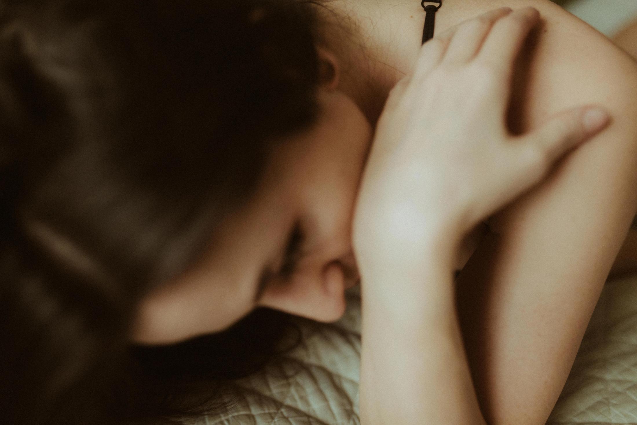 Soft-focus detail of Maya’s face and hands in close contact.
