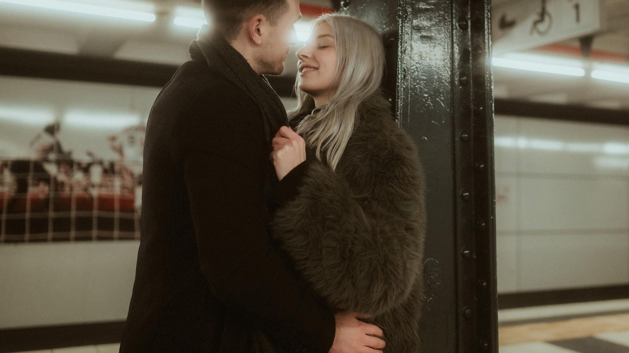 Lorelai and Steffen stand together beside a dark pillar at St. Pauli station.