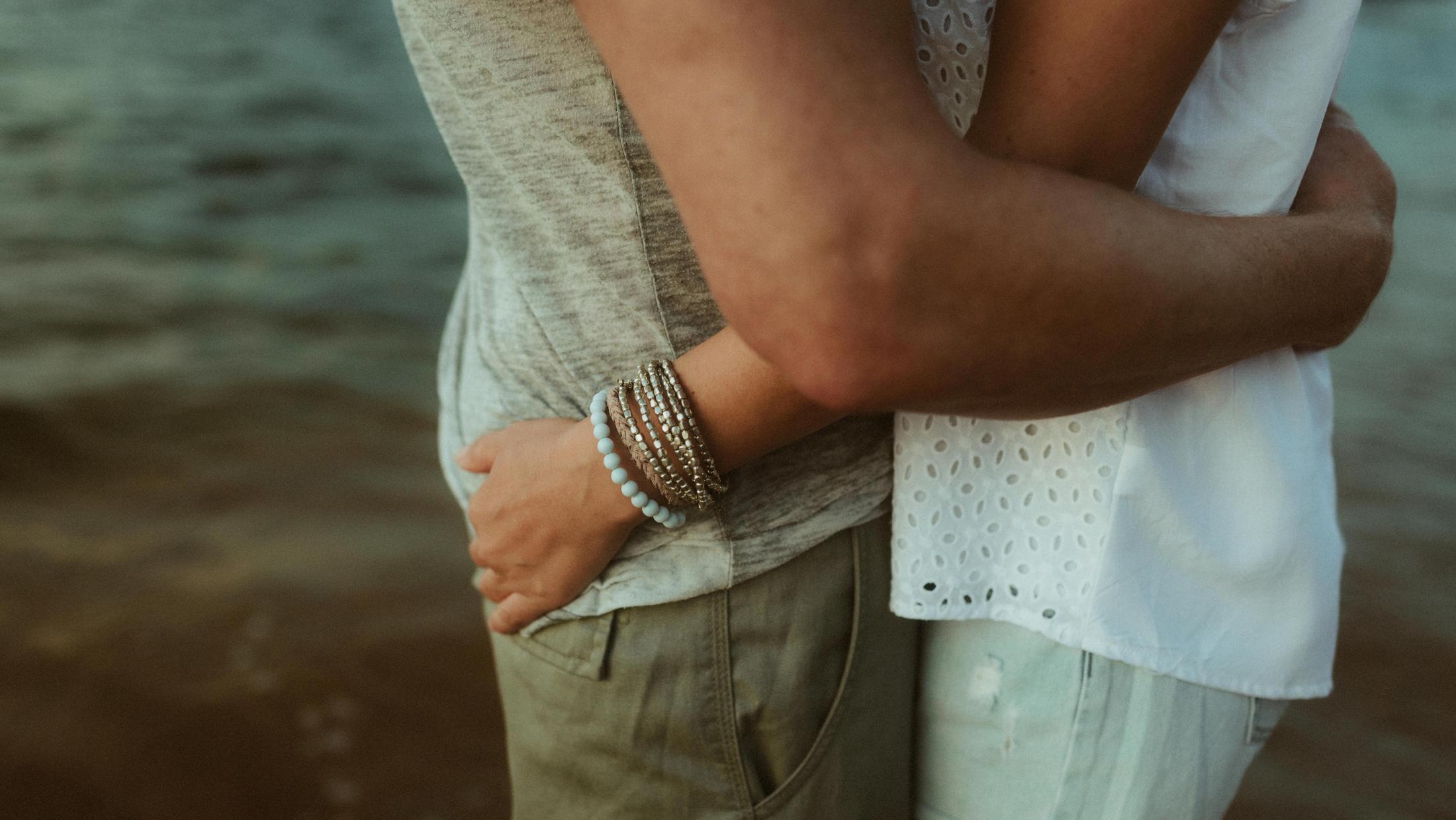 Close view of Petra's hands around Roman's waist