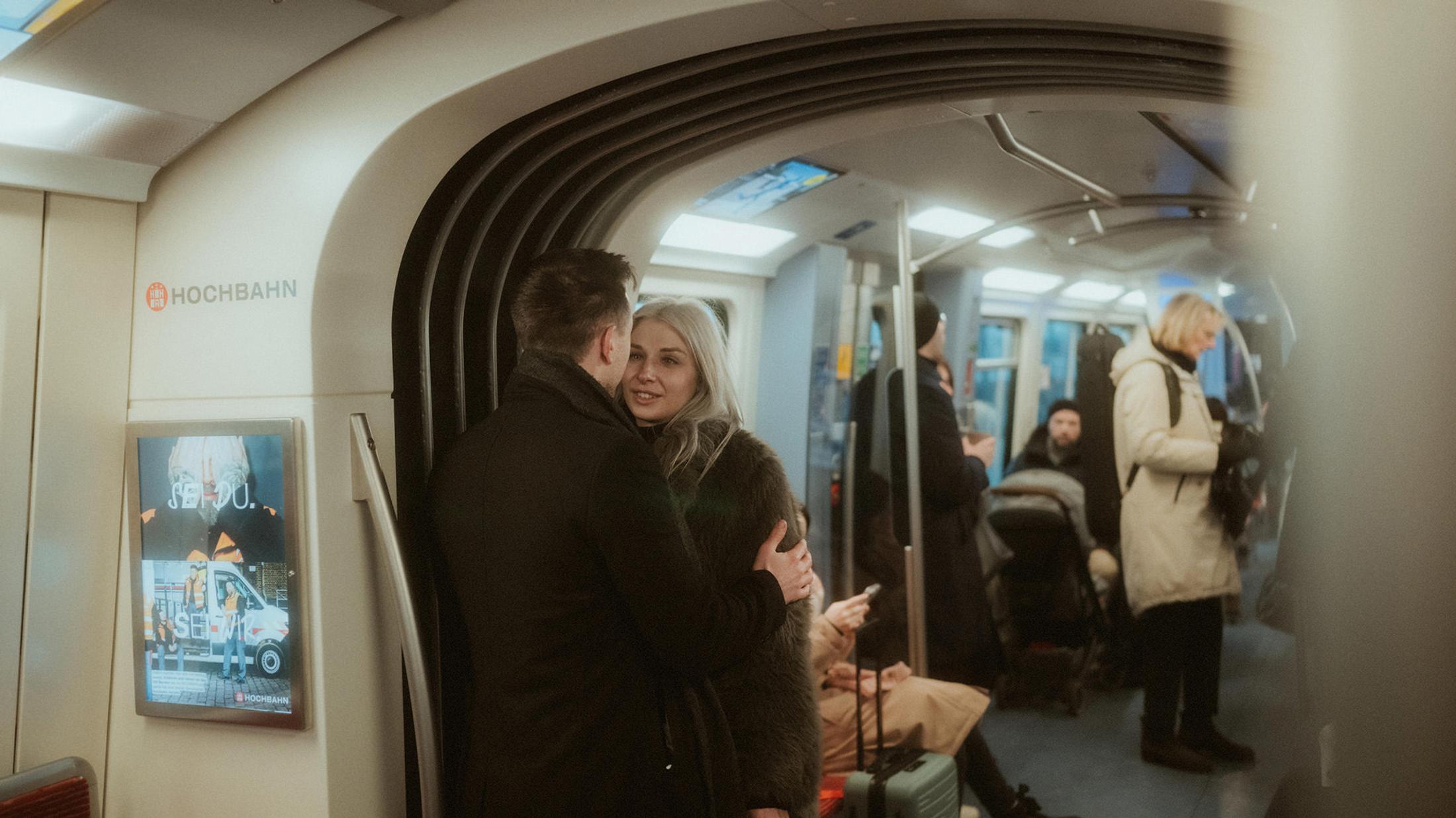 Lorelai and Steffen stand together inside a busy Hamburg U-Bahn carriage.