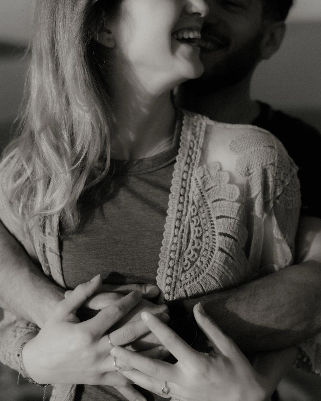 Cropped black-and-white portrait of Katja laughing beside David.