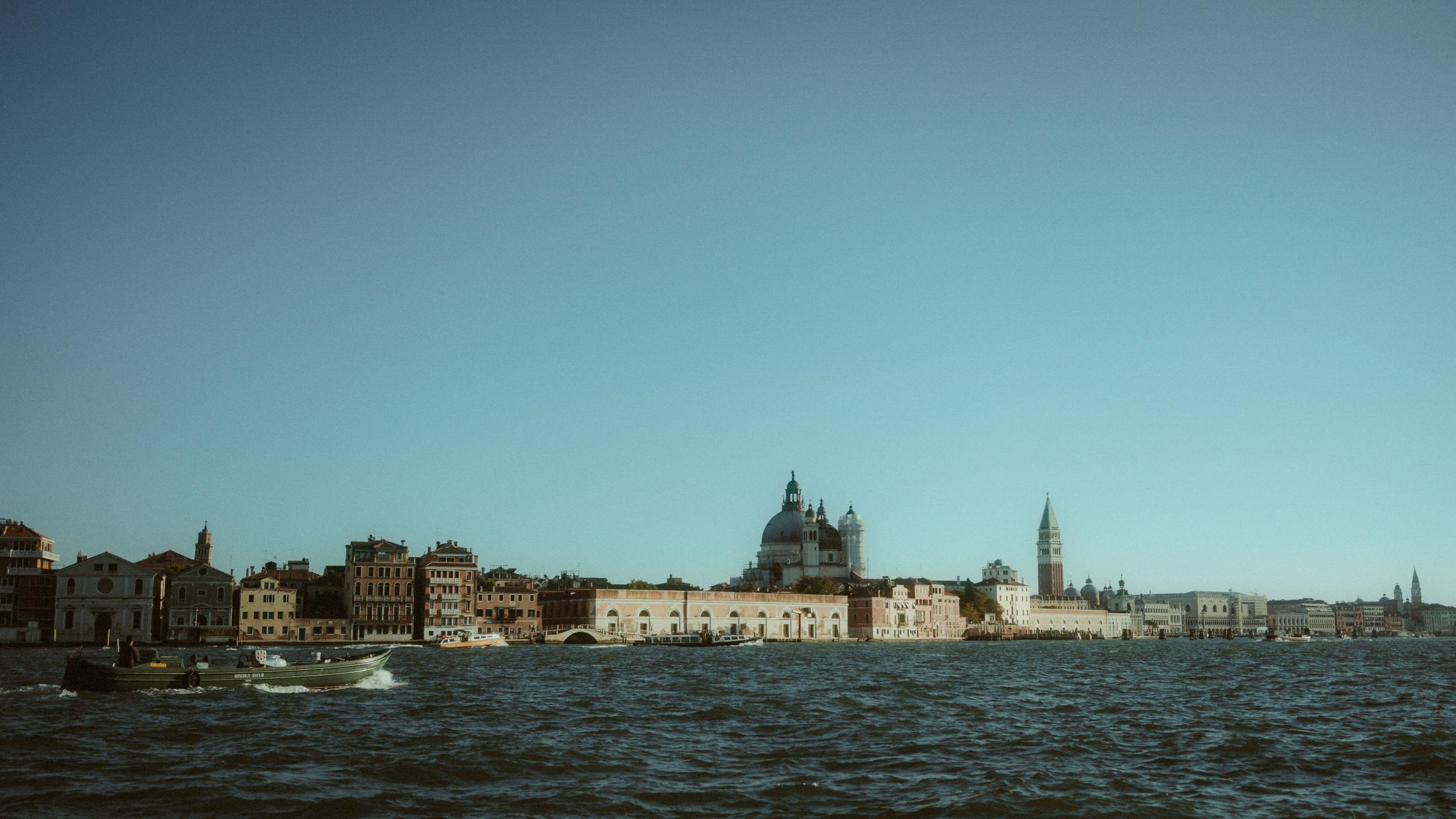 Wide view across the blue Venetian lagoon toward the distant skyline.