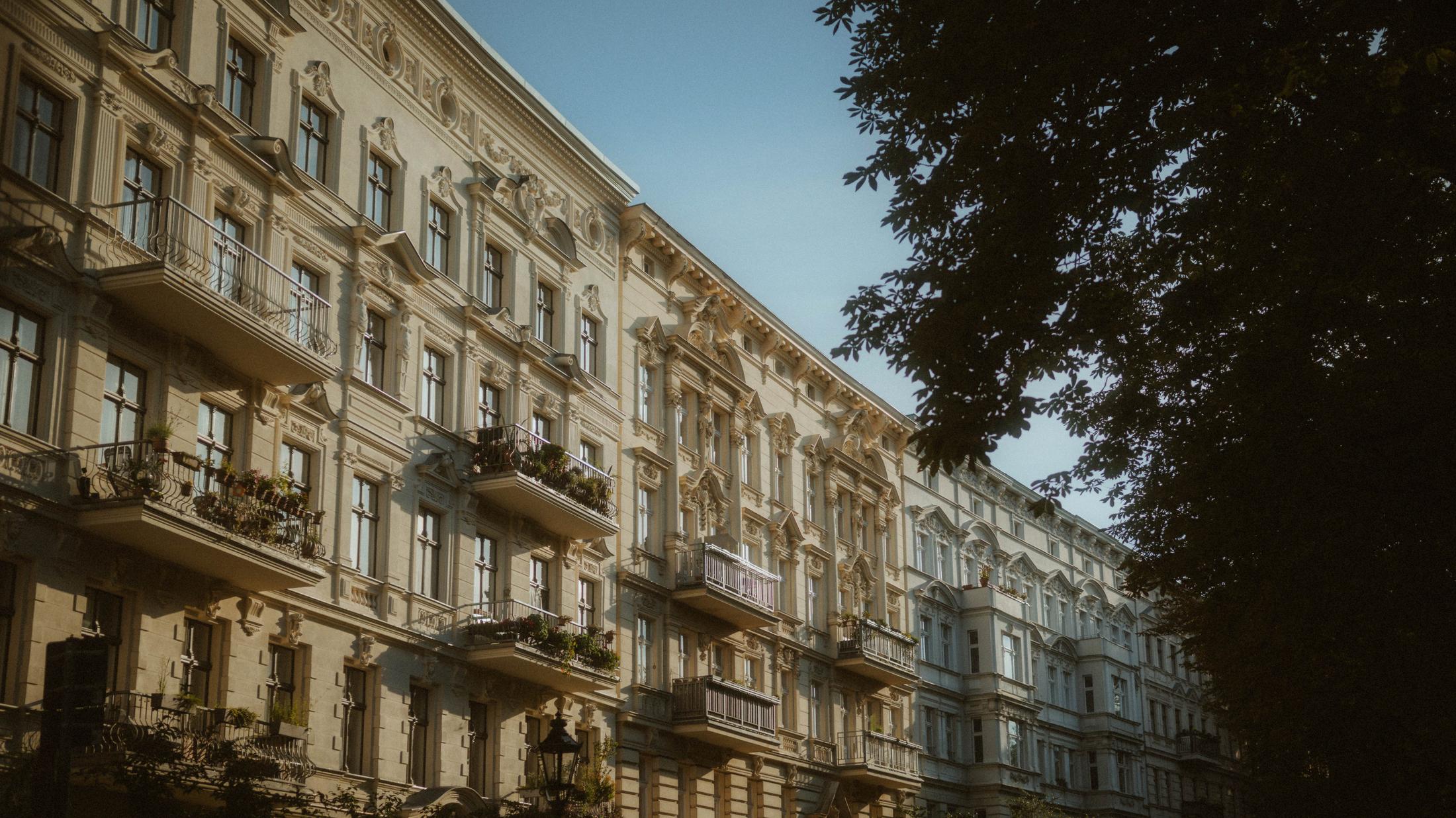 A Berlin apartment facade in warm late-afternoon light.
