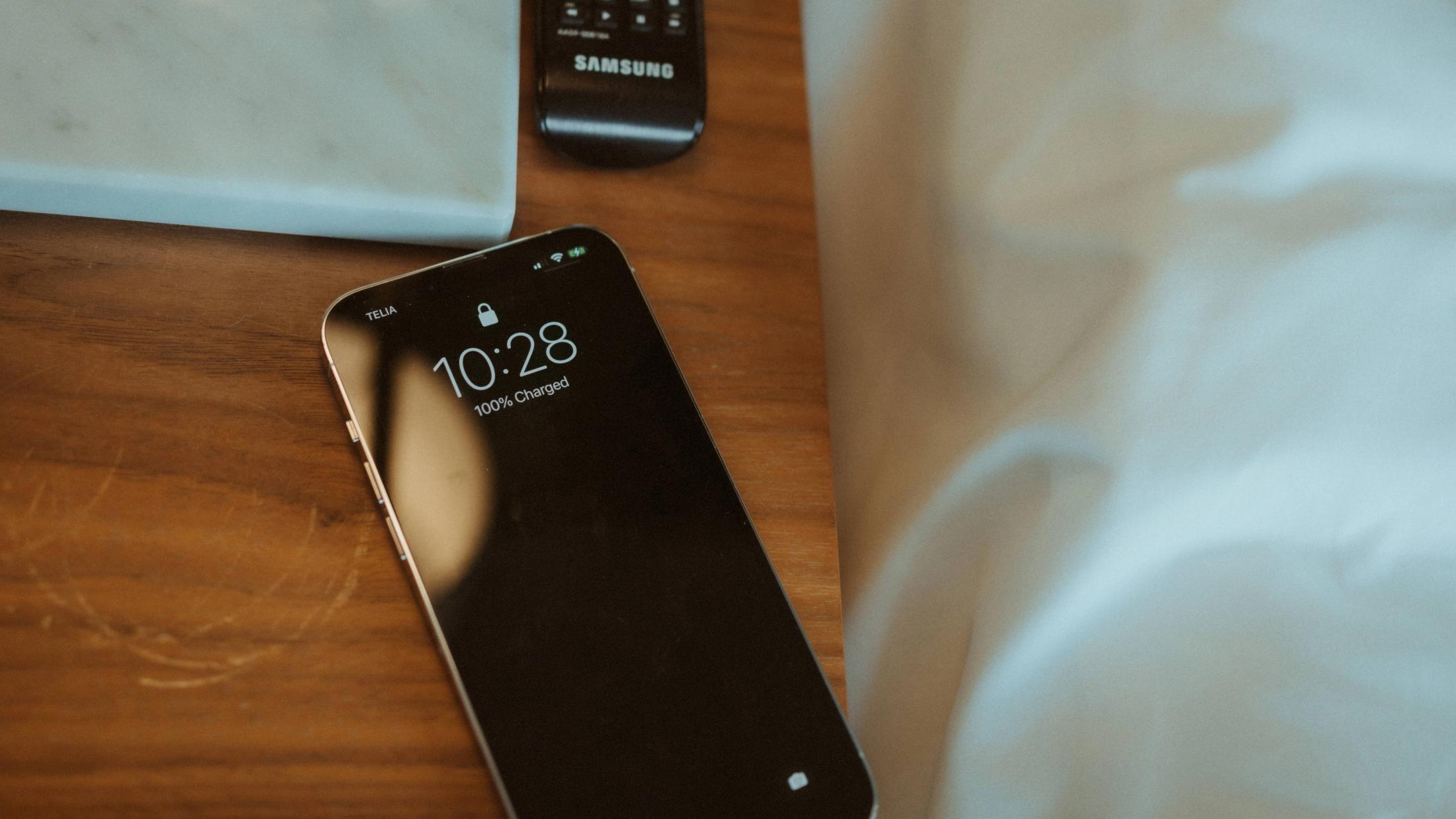 A phone on the hotel table displays the time 10:28.