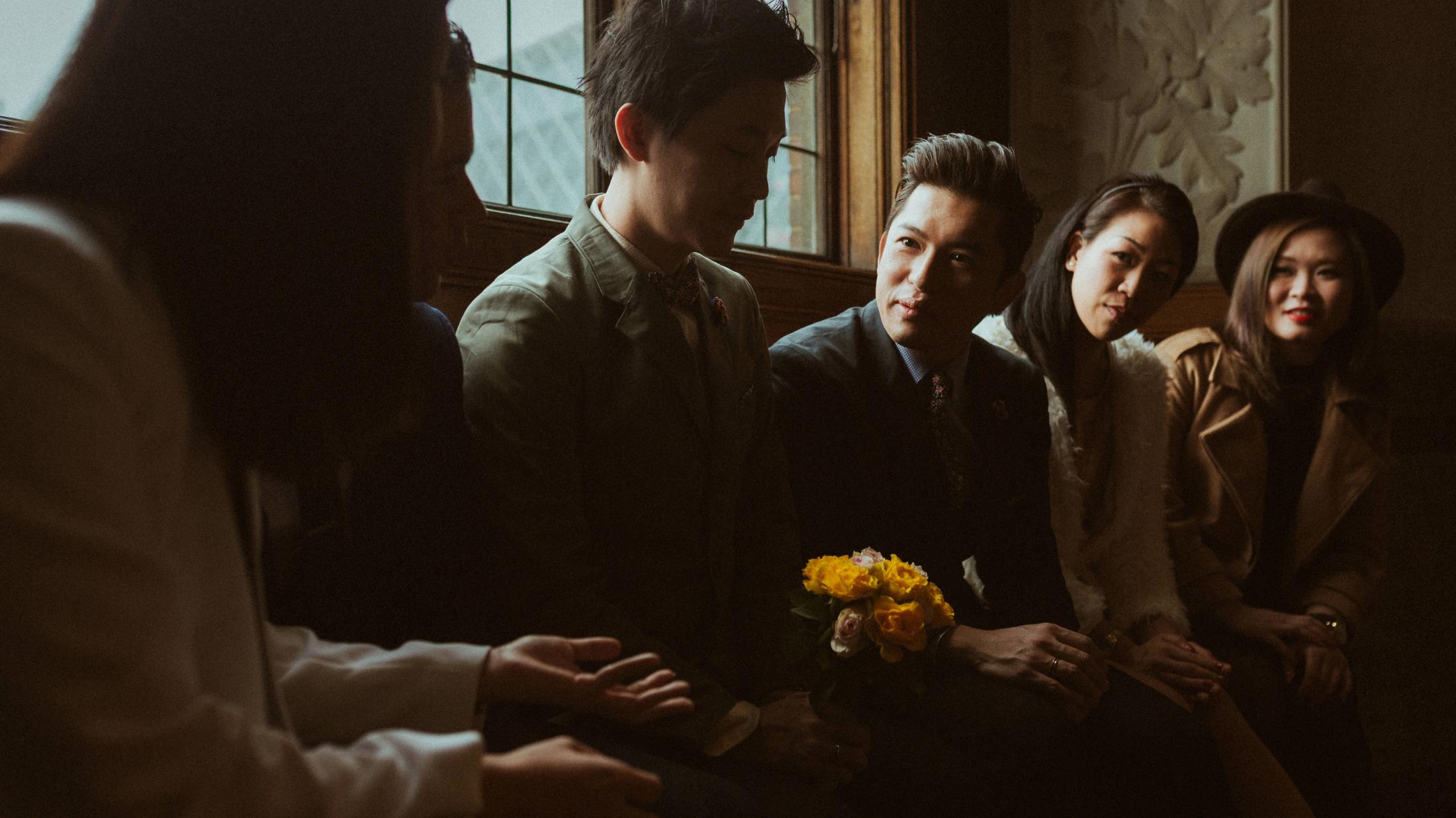 Kevin and Terence stand among their friends with flowers after the ceremony.