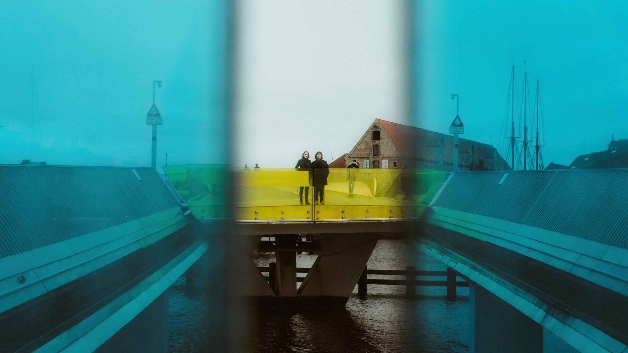 Ari and Pia distant within a blue reflection by Copenhagen harbour