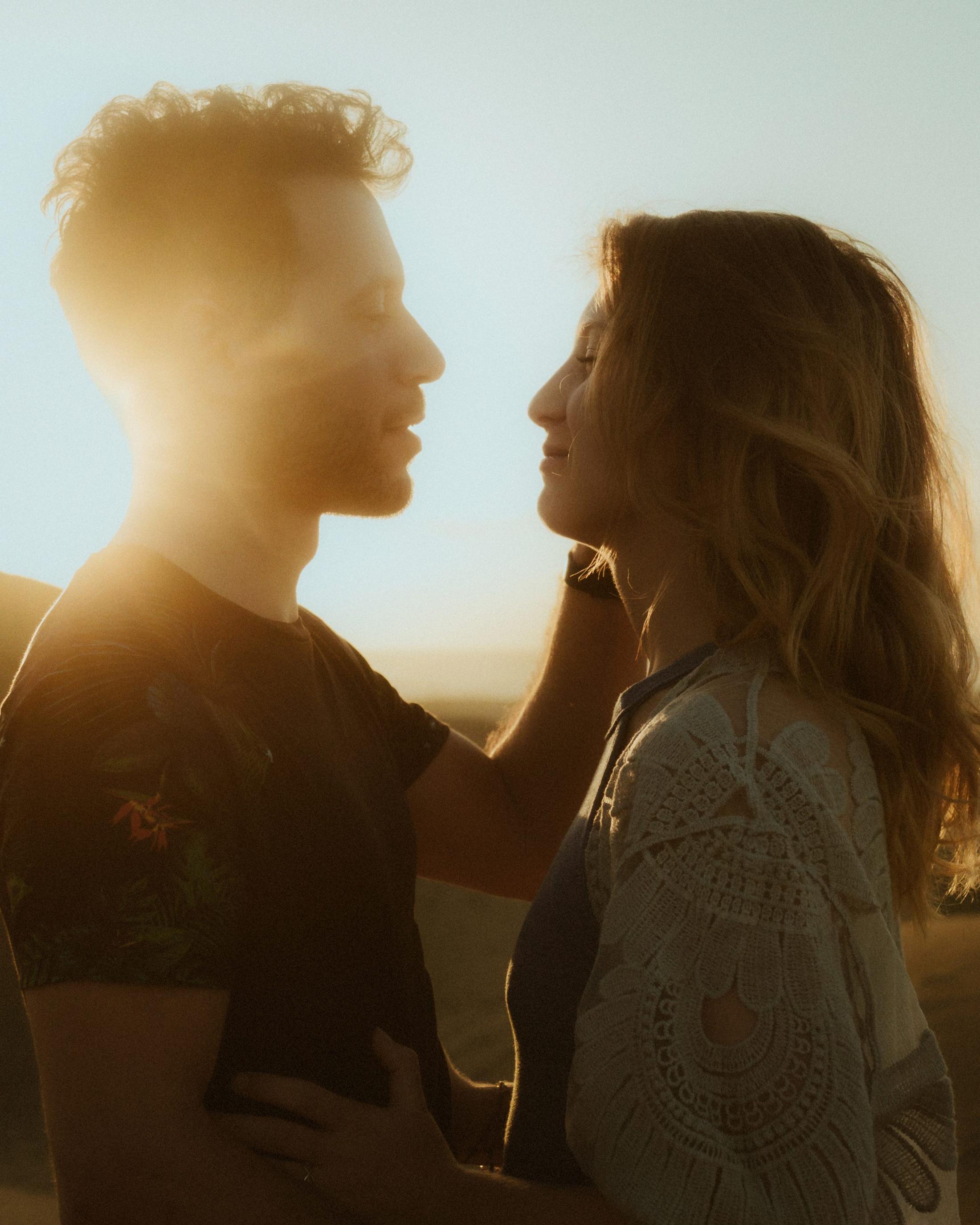 Katja and David facing each other with sunlight obscuring part of his face.