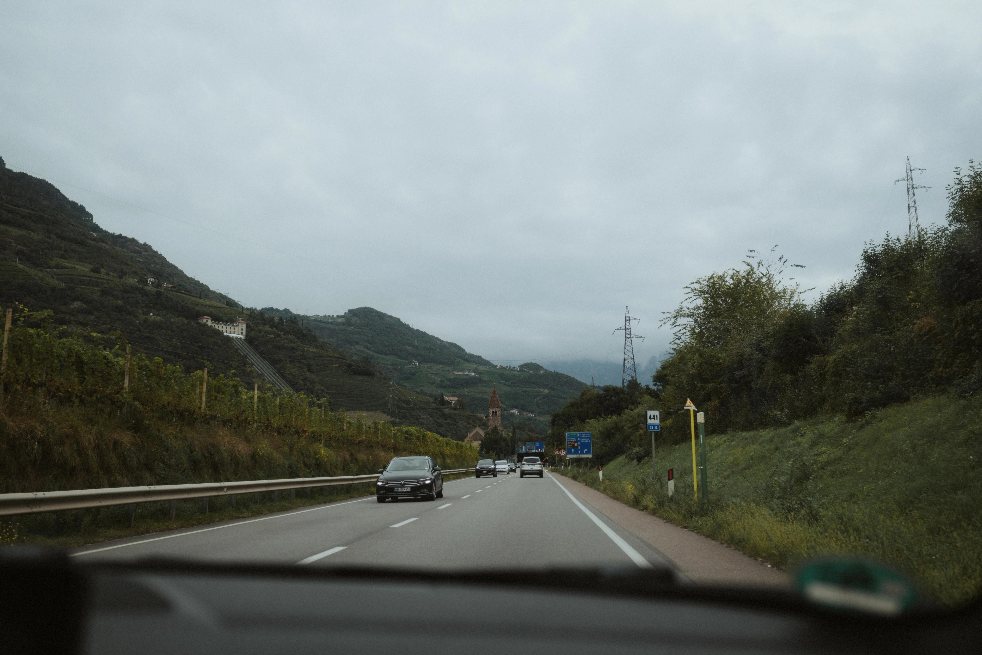 View through a car windscreen along the road toward Seiser Alm.