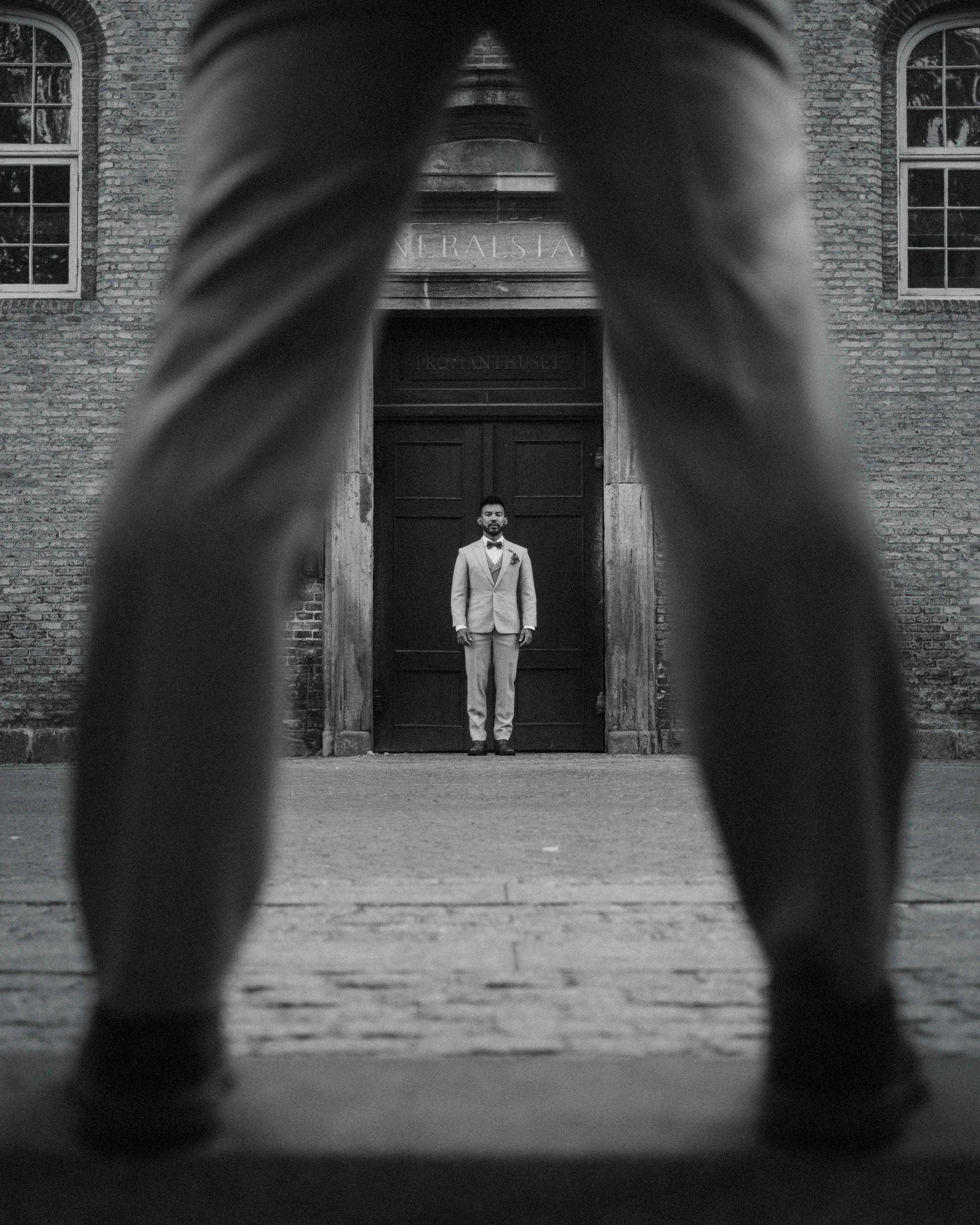 Black-and-white street portrait framing Kris between Ilya's legs.