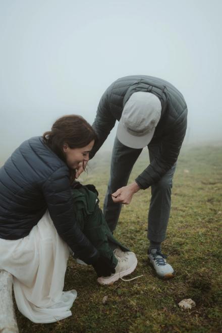 Jana and Steffen bending over a shoe in a foggy meadow