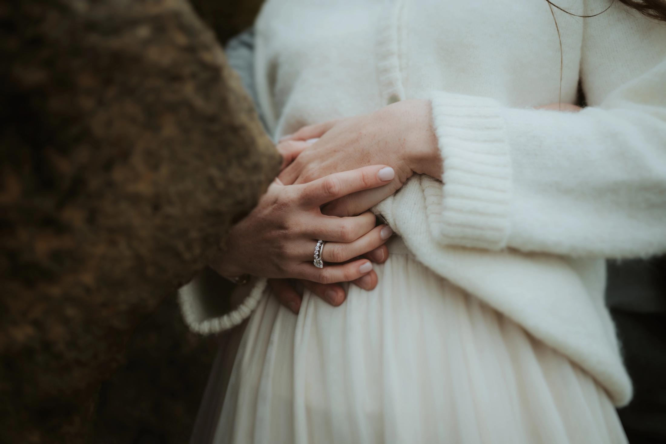 Close view of Jana and Steffen's hands and rings resting on a rock.