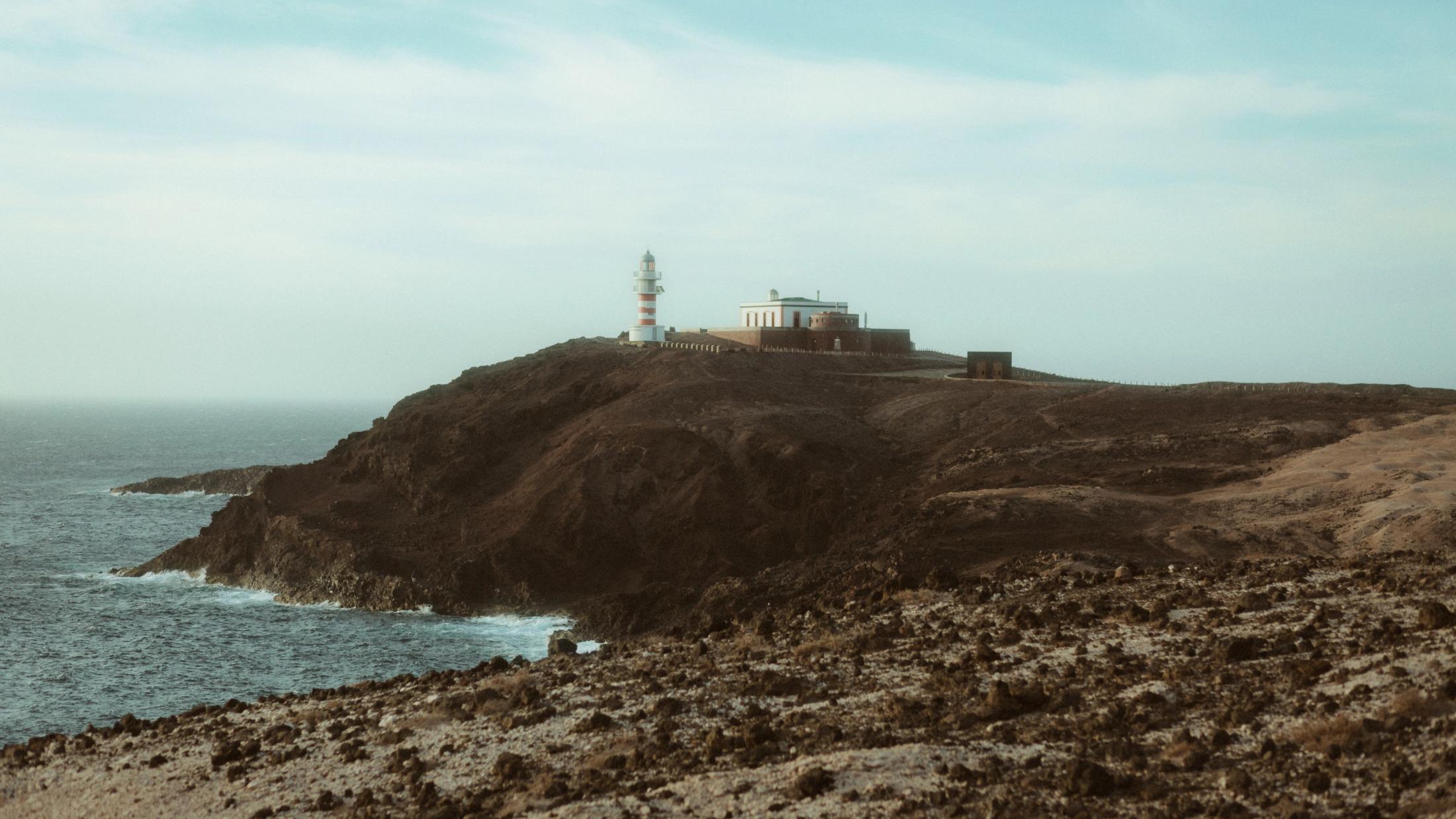 Ein Leuchtturm auf einer Klippe an der Küste.