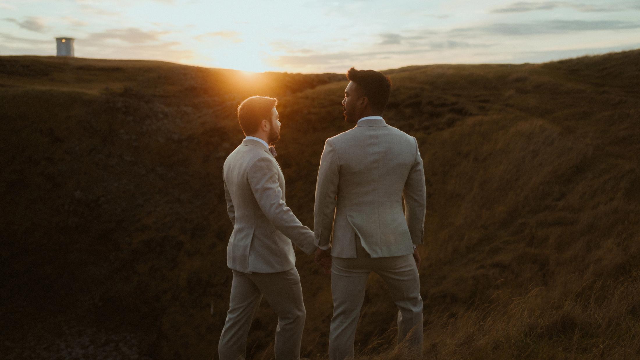 Tiefes Sonnenlicht trifft das Gras, während Kris und Ilya zum Horizont blicken.