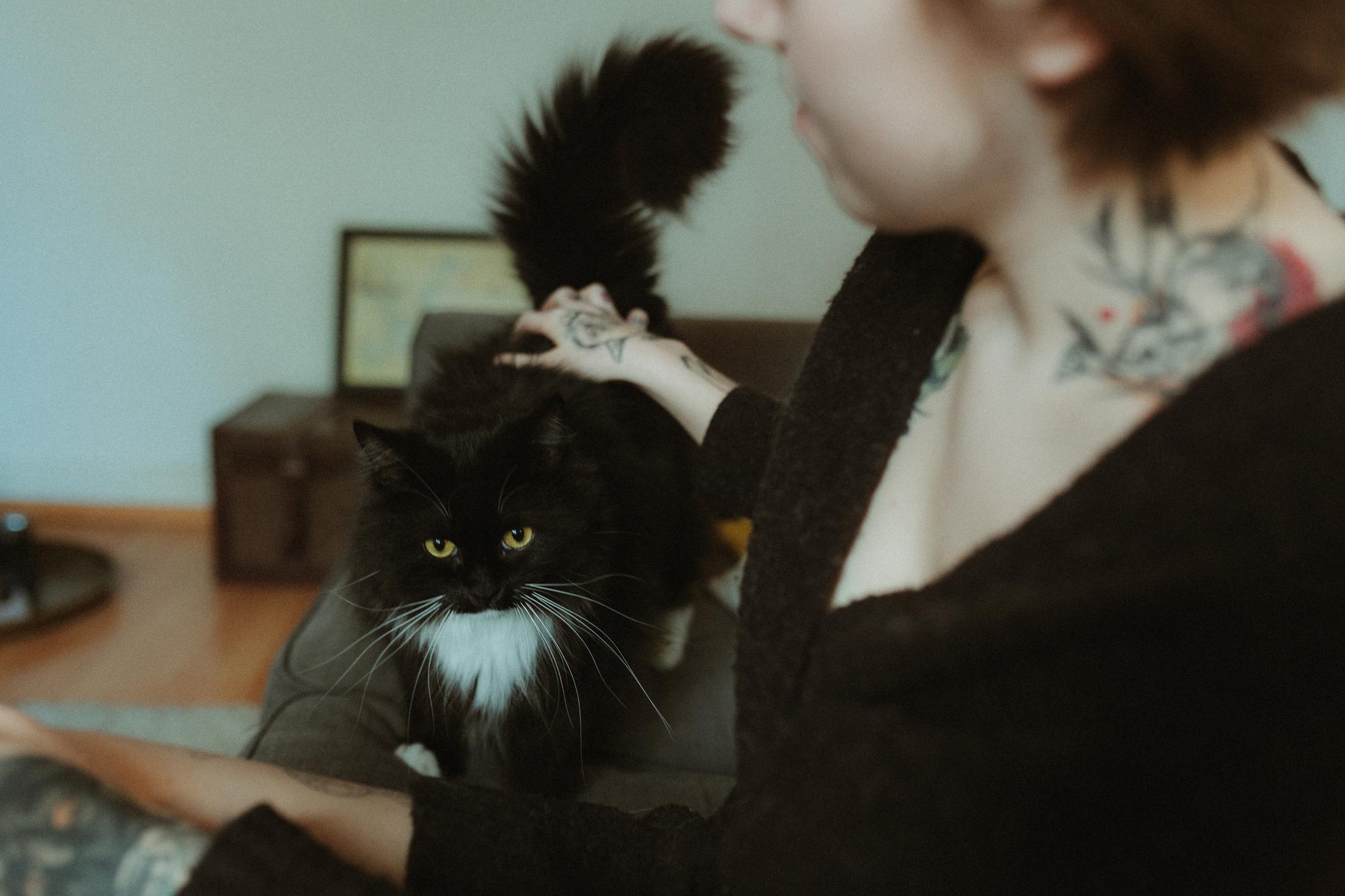 Anki holds her black cat close to her chest.